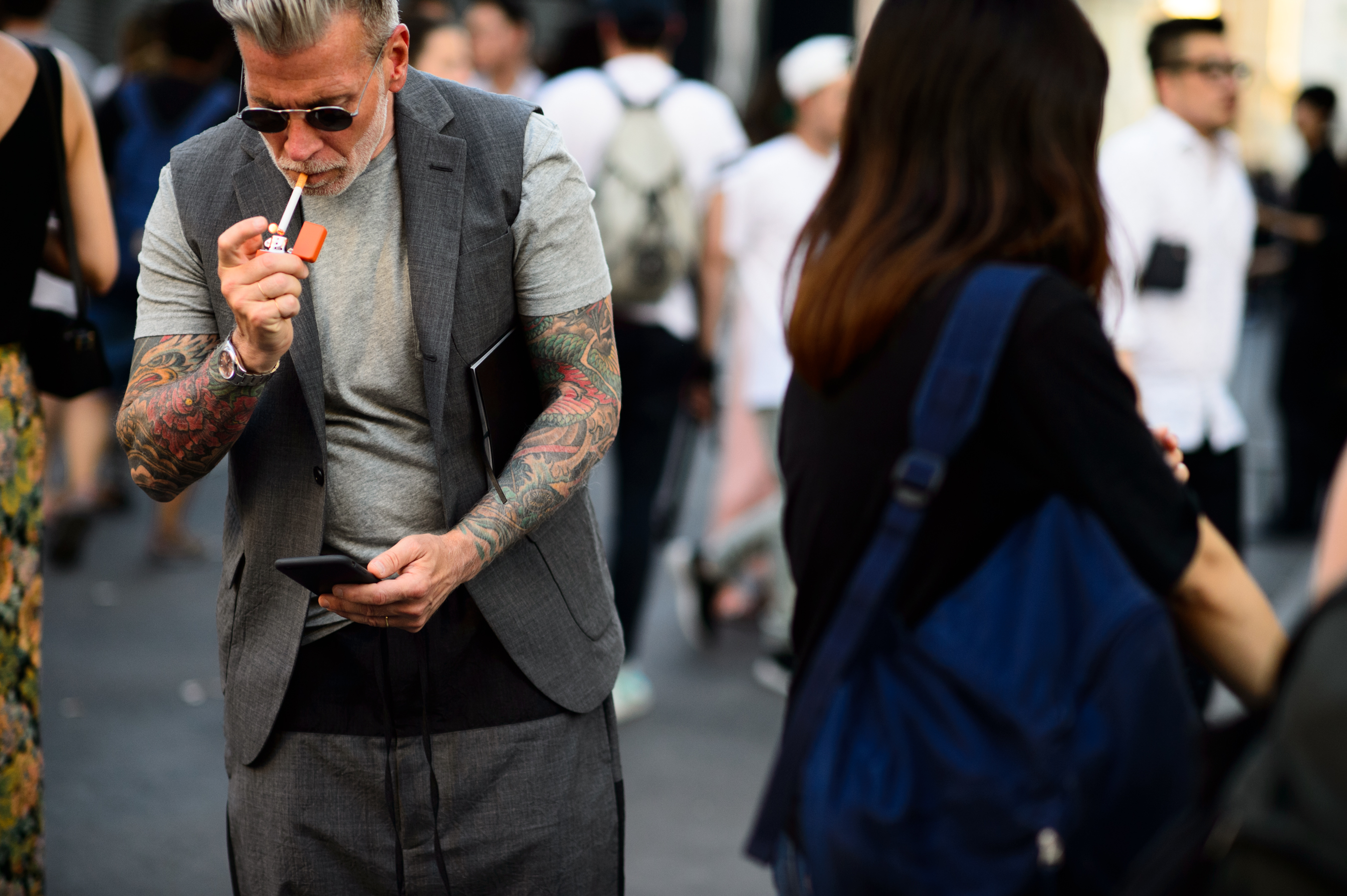 American man lighting a cigarette before a fashion show