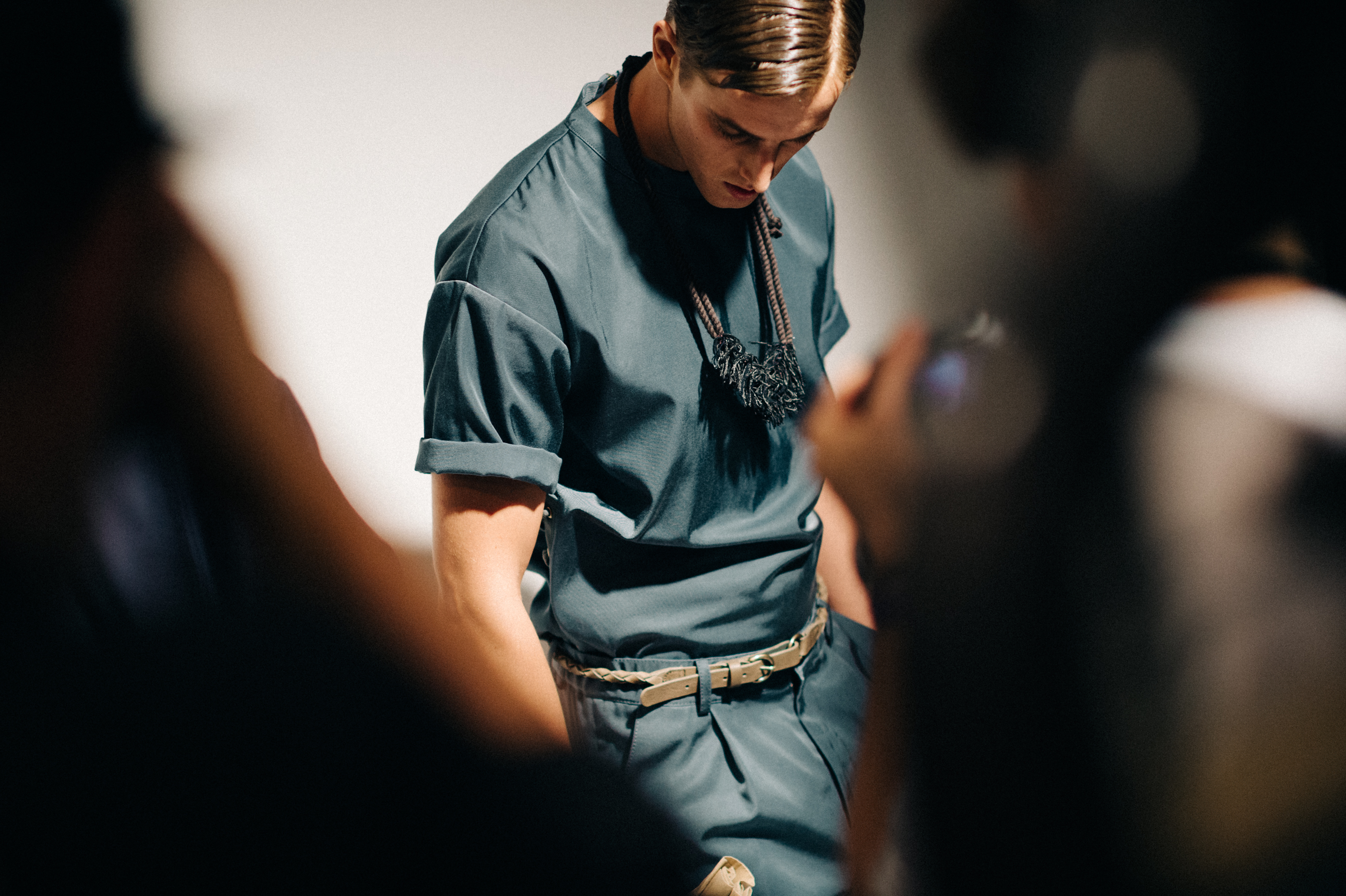 Male model wearing blue outfit before the show