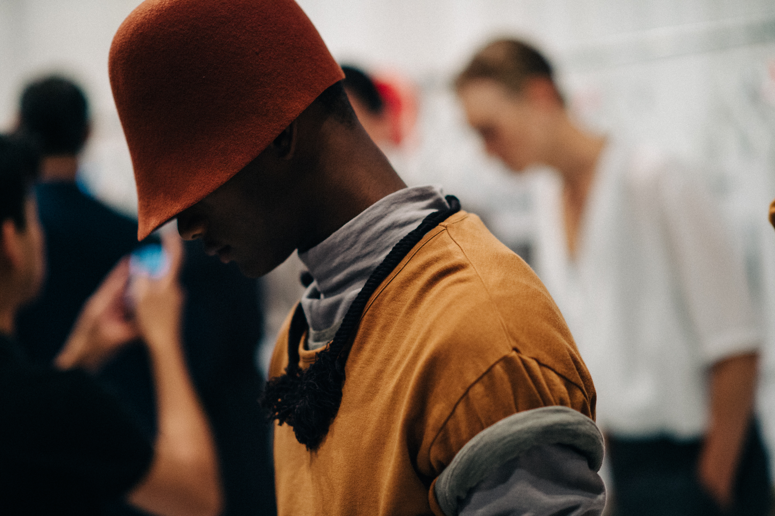 Male model wearing red hat before the show