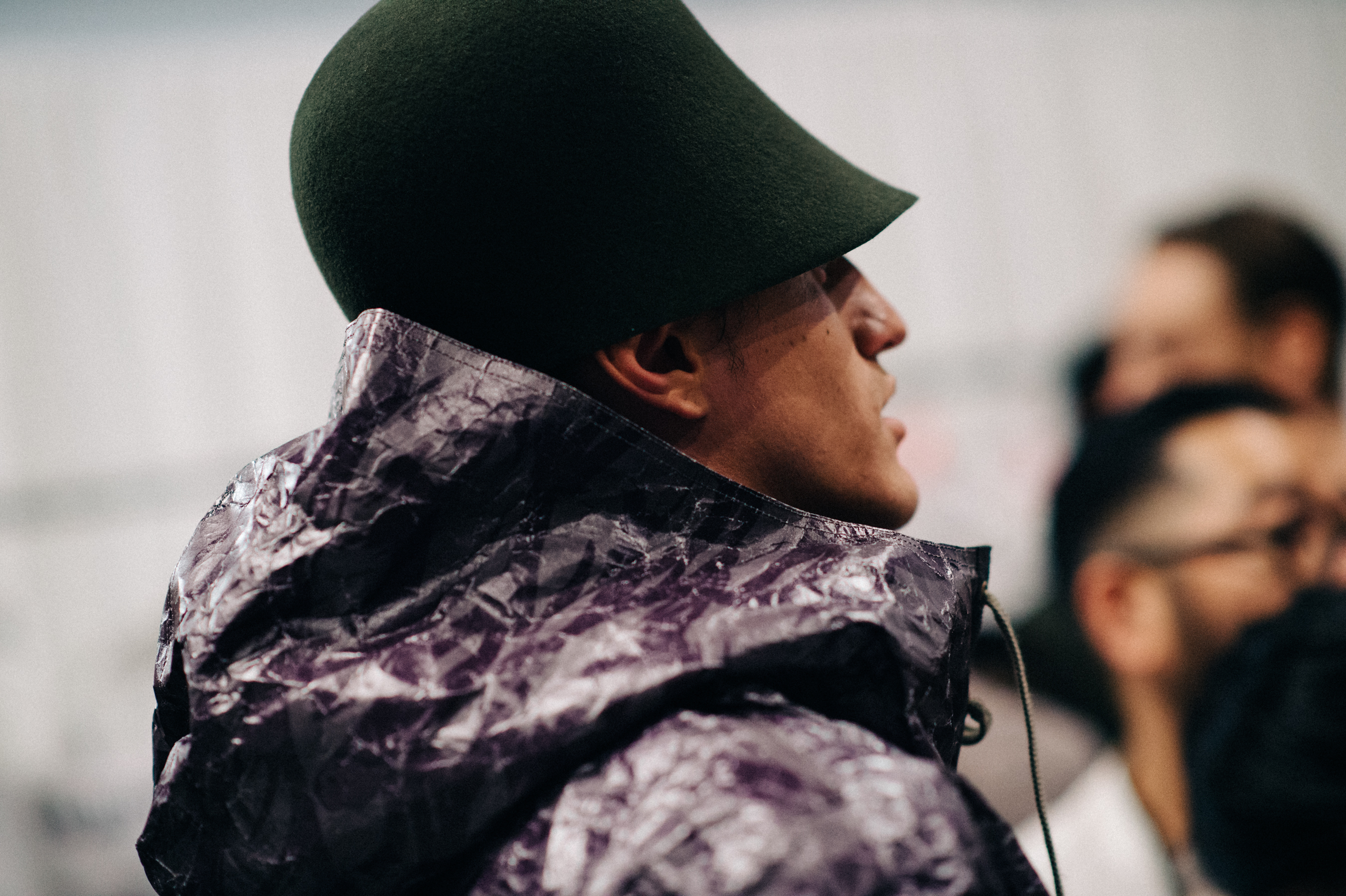 Male model wearing green hat and shiny jacket