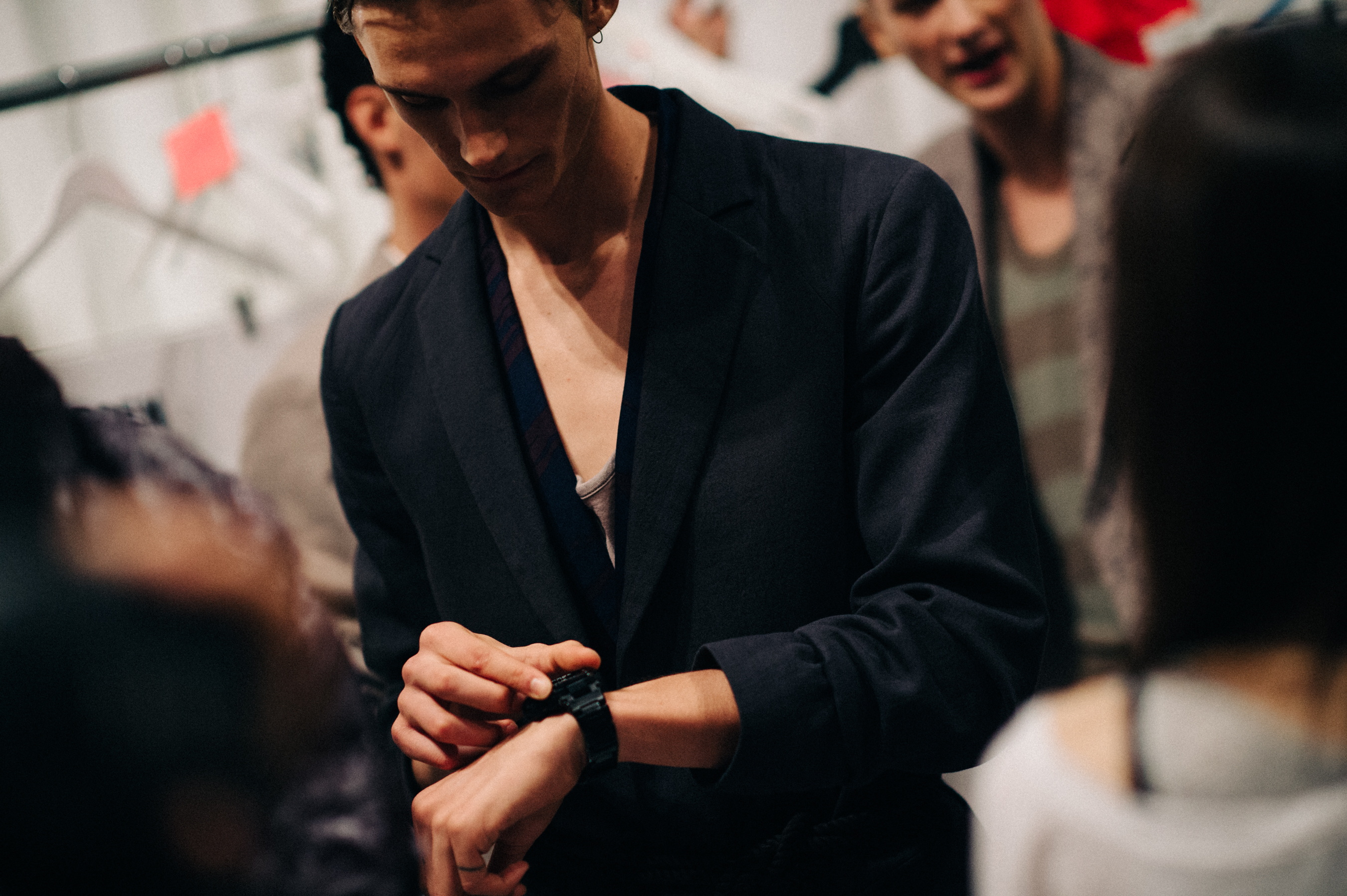 Male model looking at his watch before the show