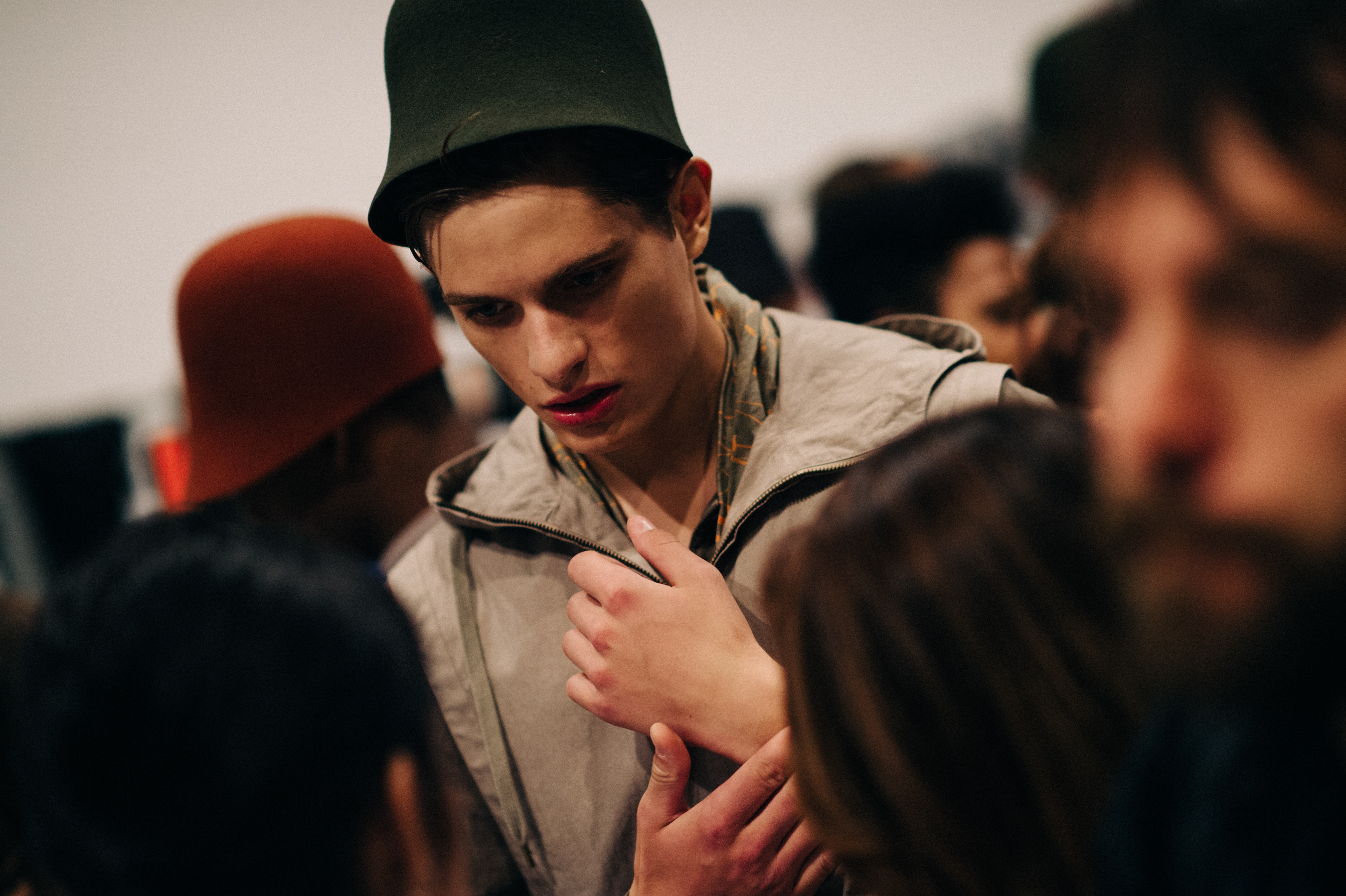 Male model wearing green hat before the show