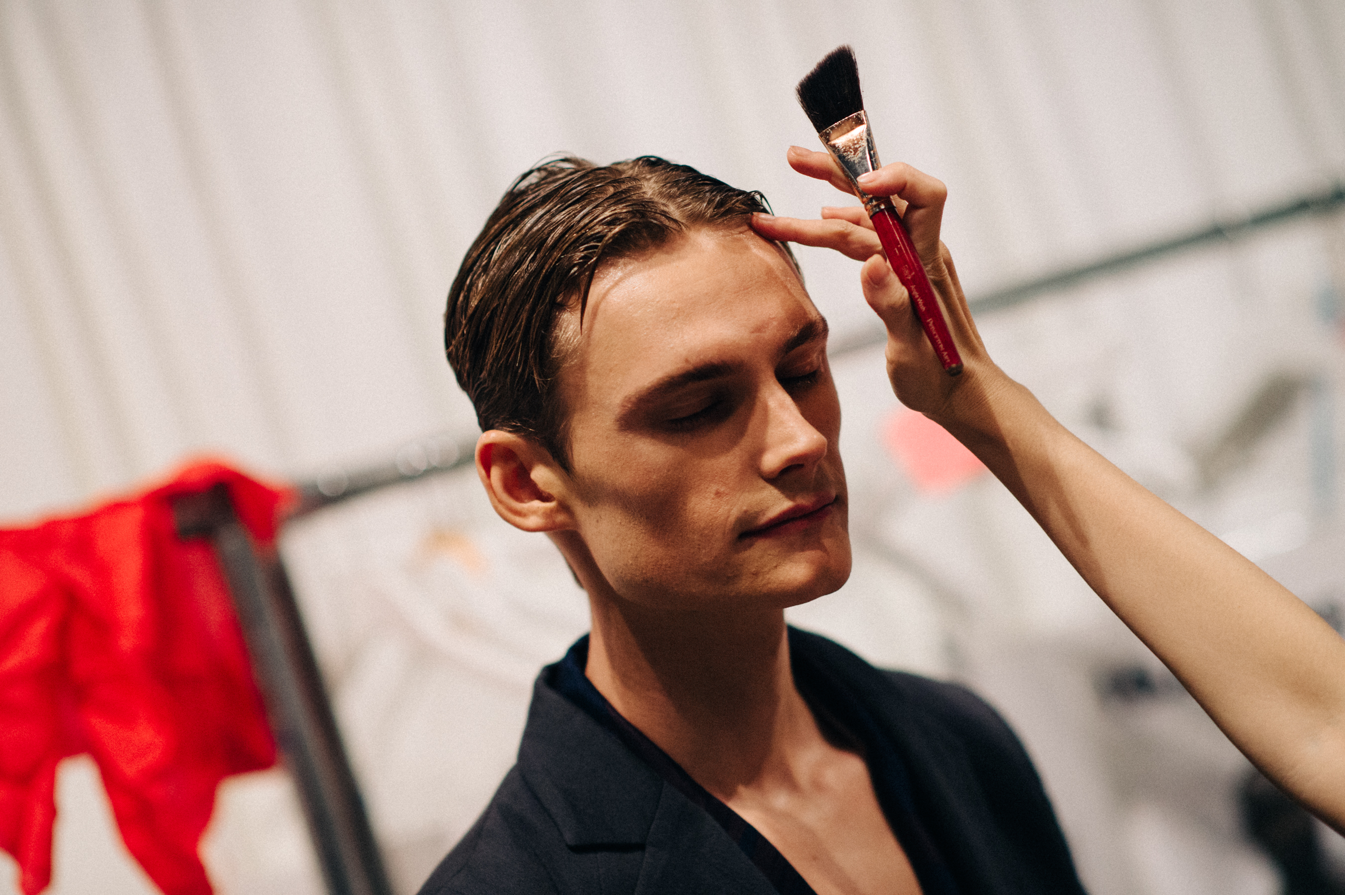 Male model getting hair done before the show