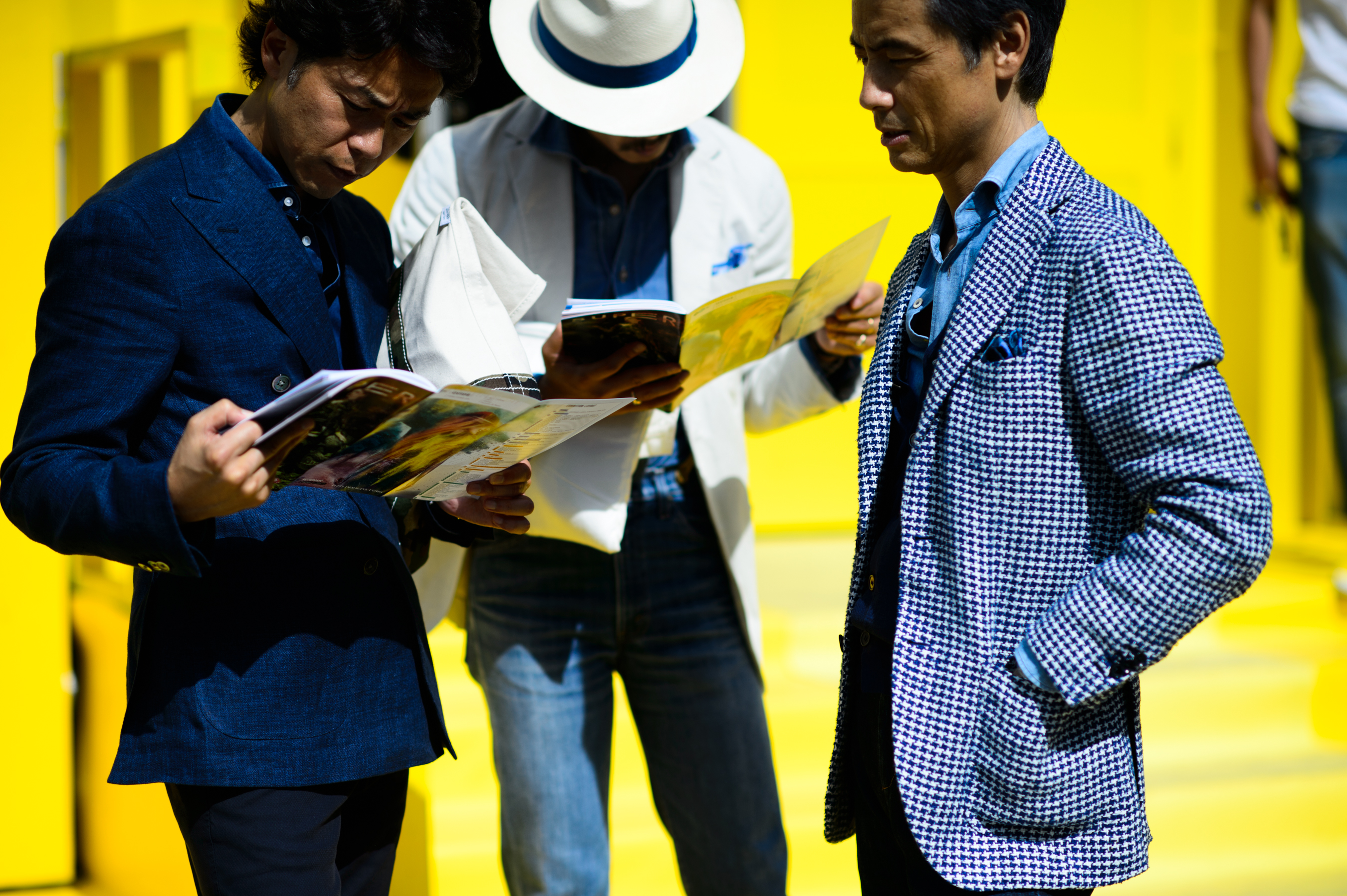 Three men reading magazines