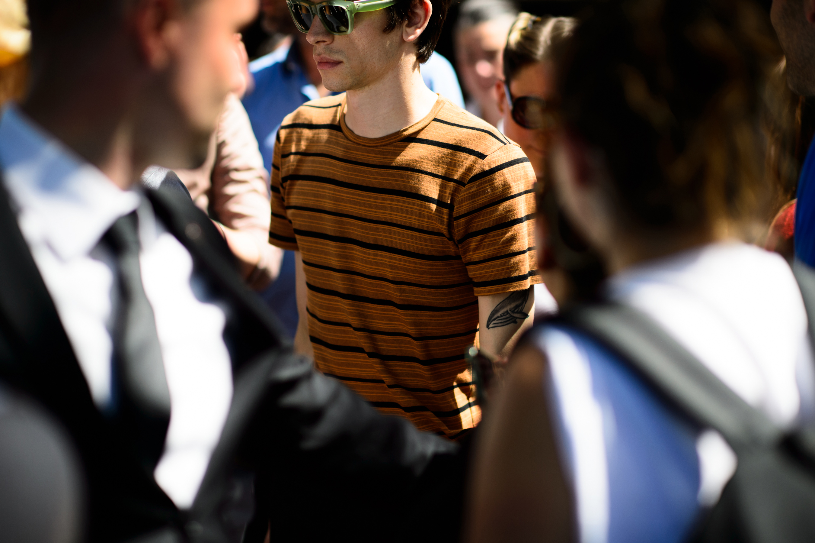 Man wearing orange striped shirt and green glasses