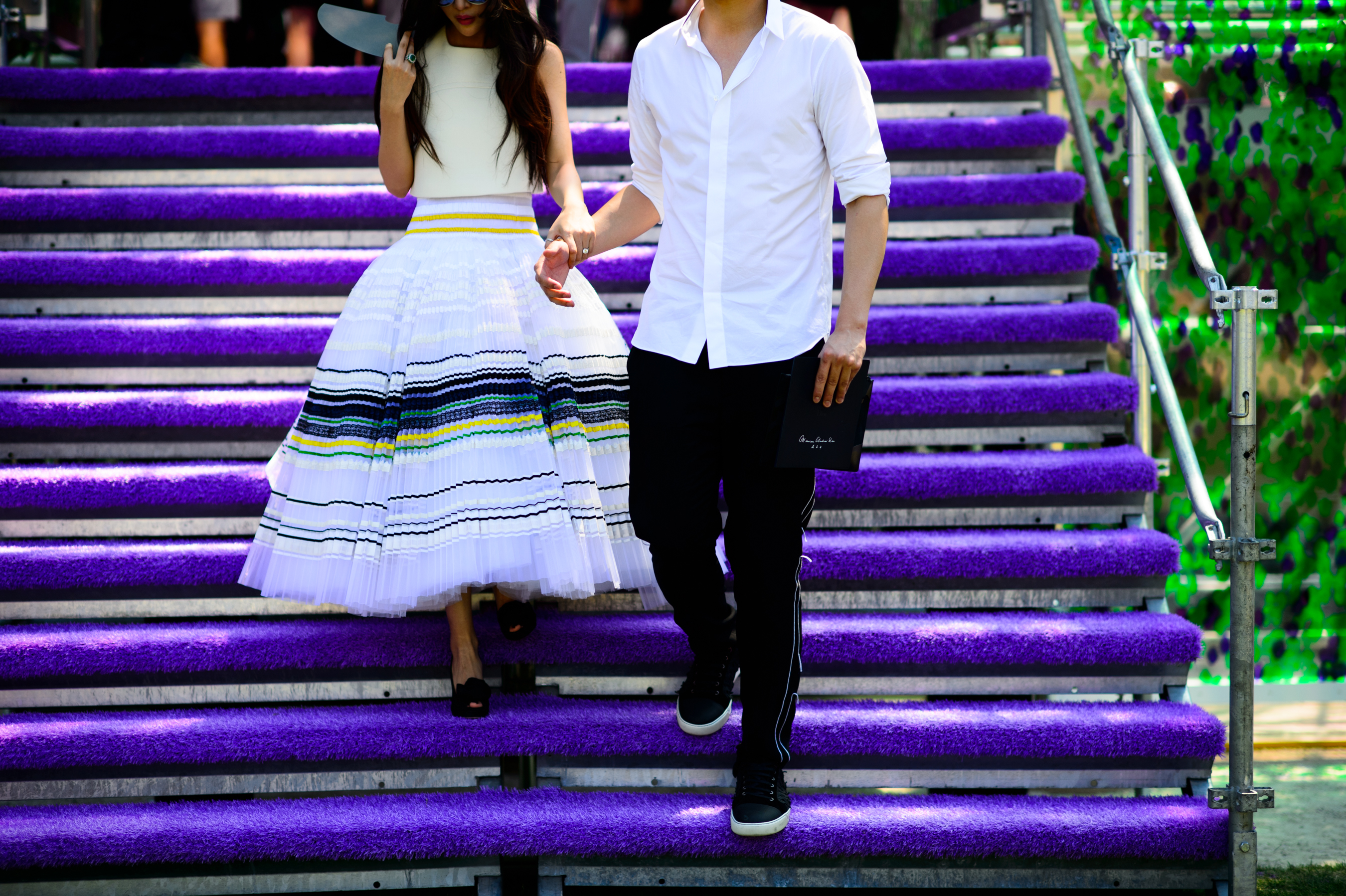 Woman in couture dress walking down the purple stairs