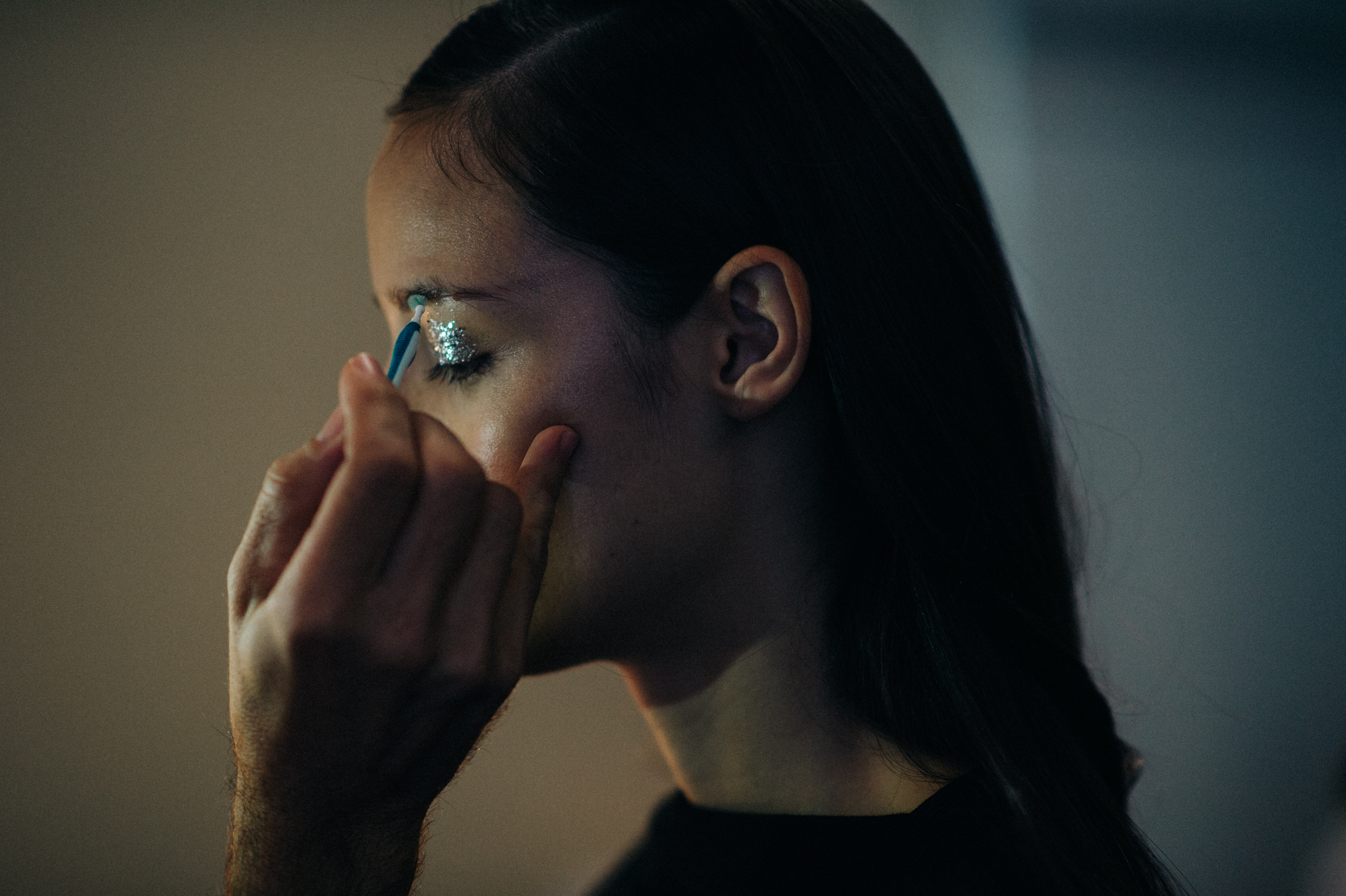 Model getting shiny make up done before the show
