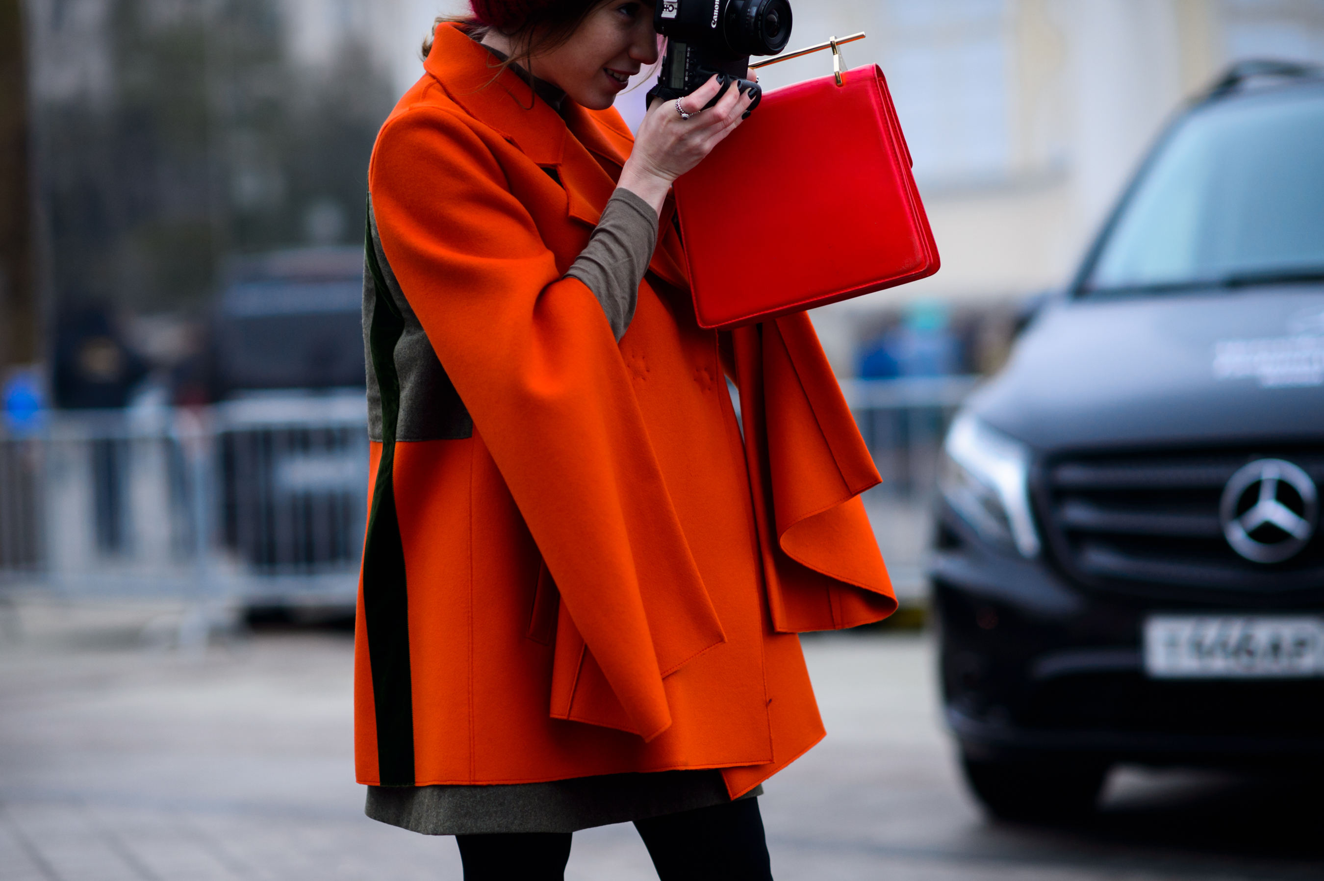 Girl in red jacket taking a photo
