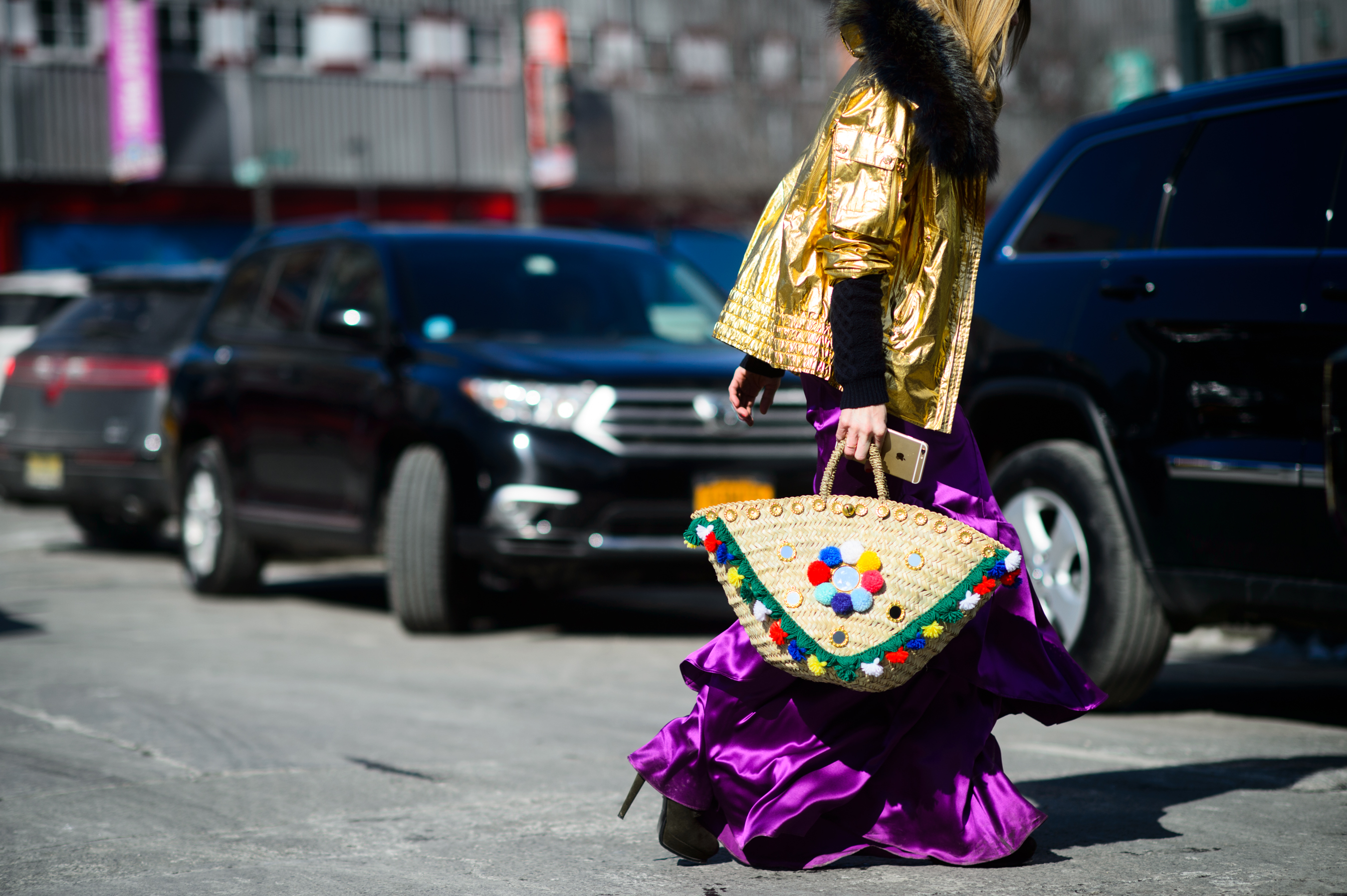 Woman in golden jacket crossing the road