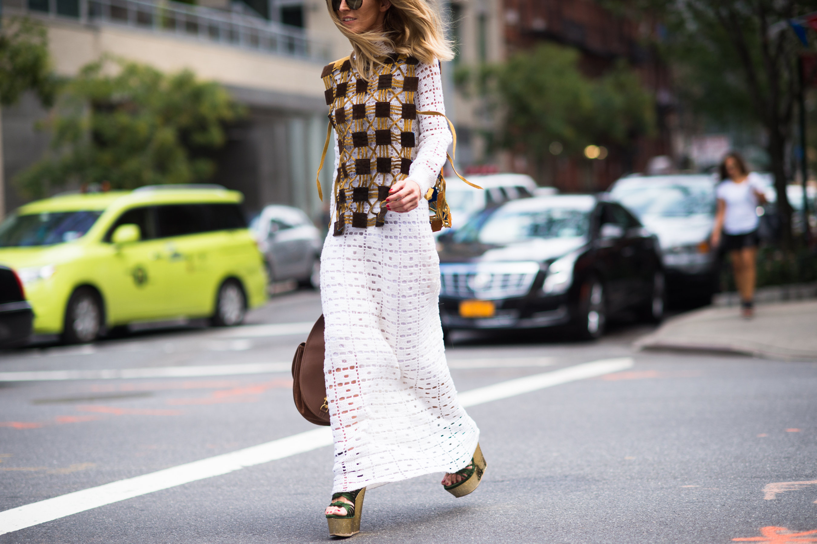 Woman wearing white dress and knitted vest on top