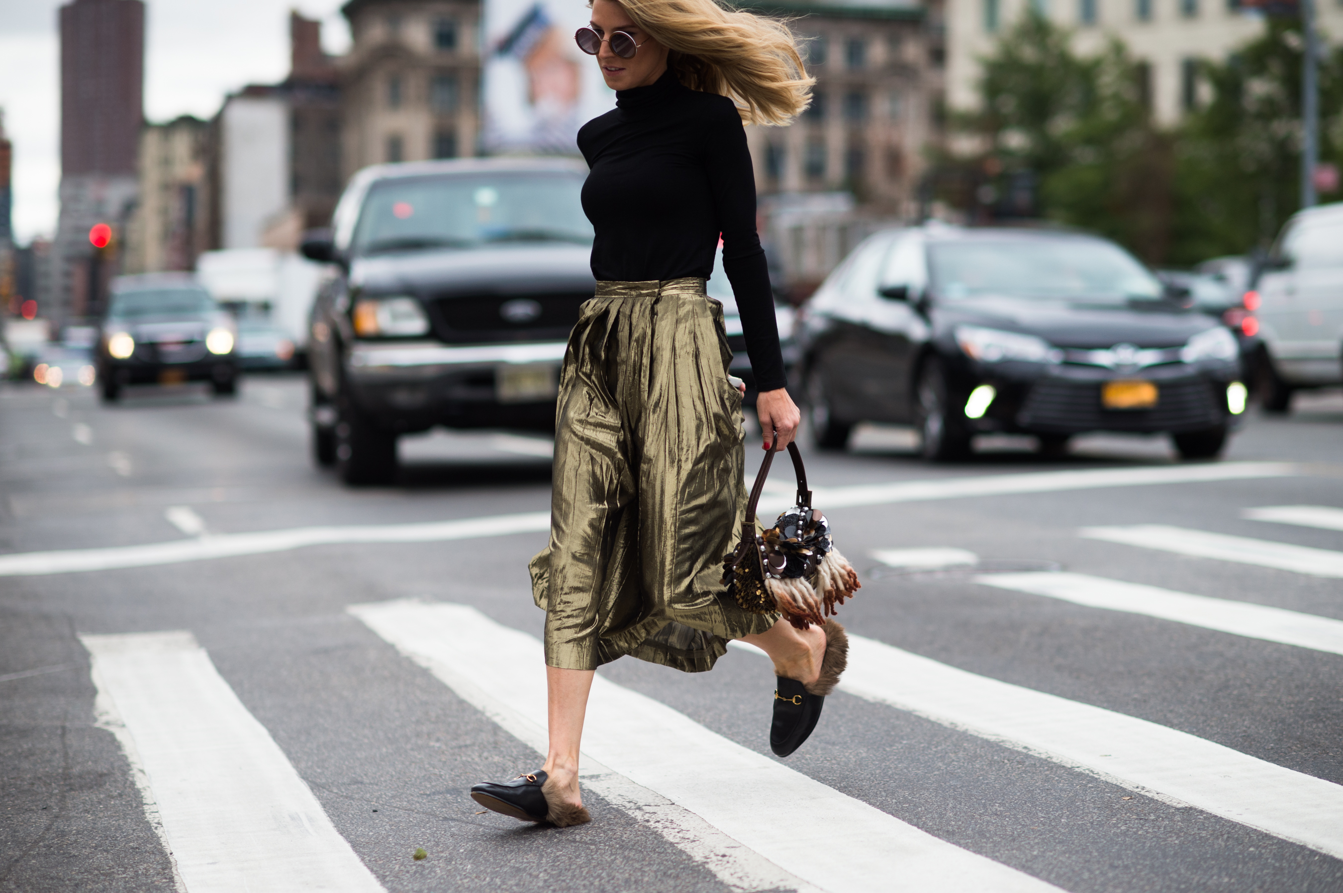 Woman crossing the street in shiny skirt
