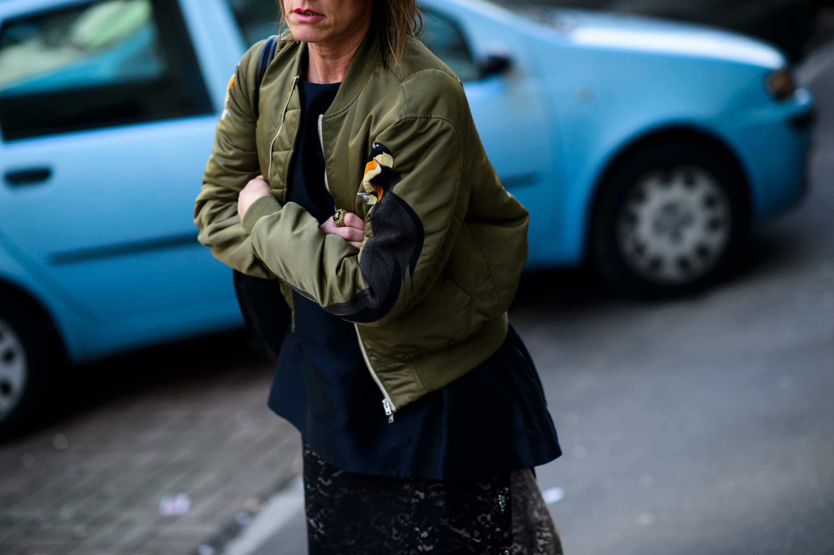 Woman wearing green bomber jacket with embroidery
