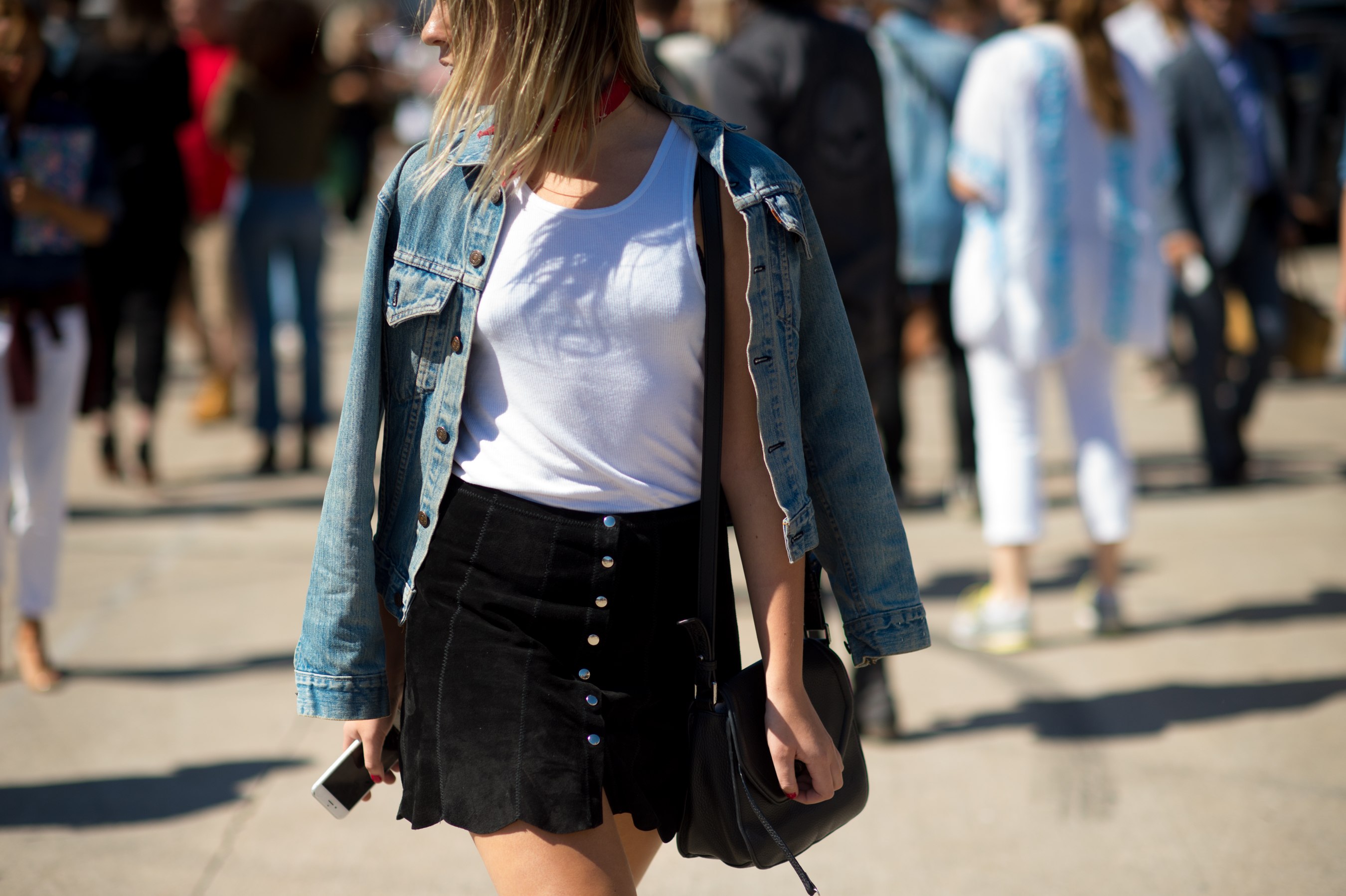 Woman in denim jacket and white tank top
