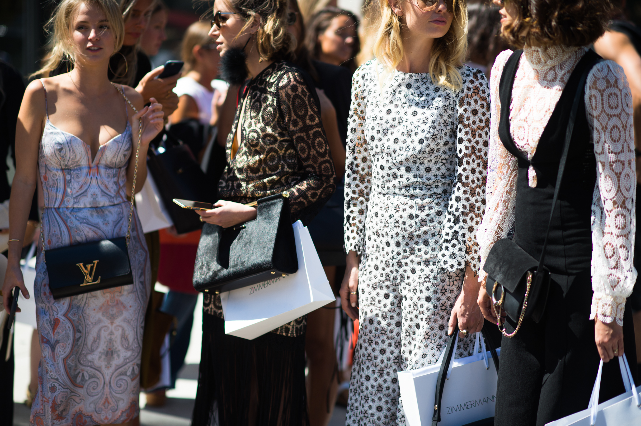 Four women wearing patterned dresses
