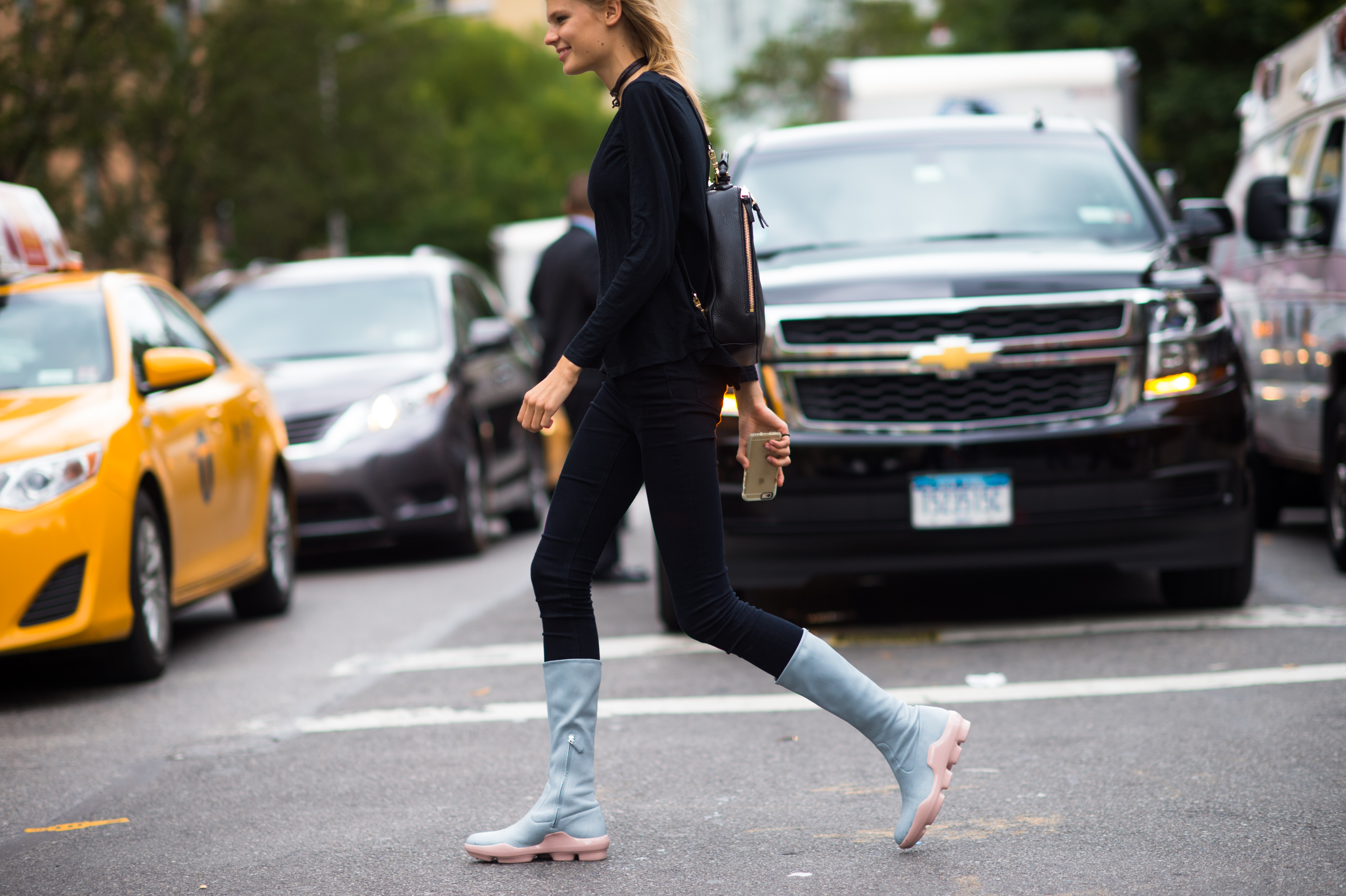 Model in blue boots crossing the street