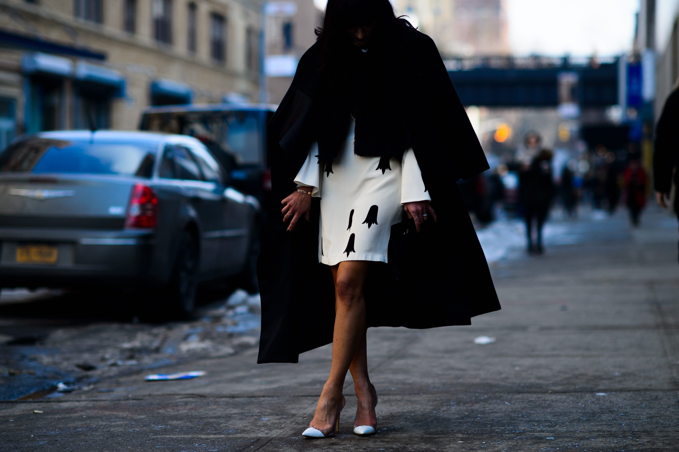 Woman wearing white dress and black coat