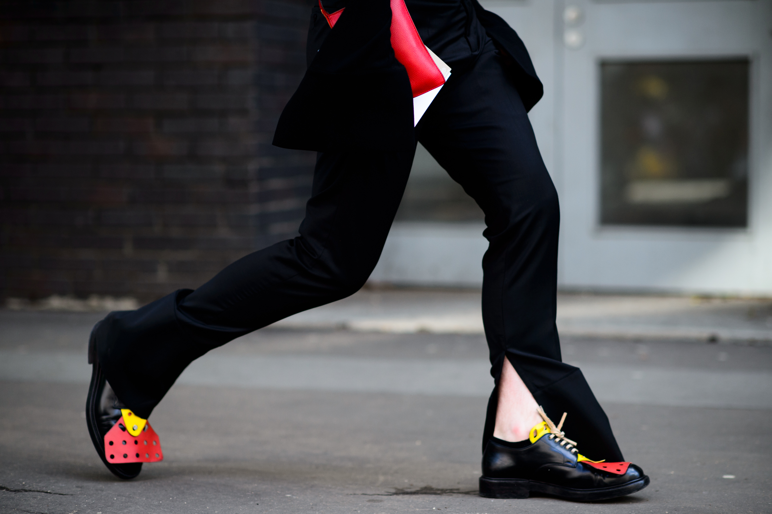 Close up of black pants with opened edges and brogues