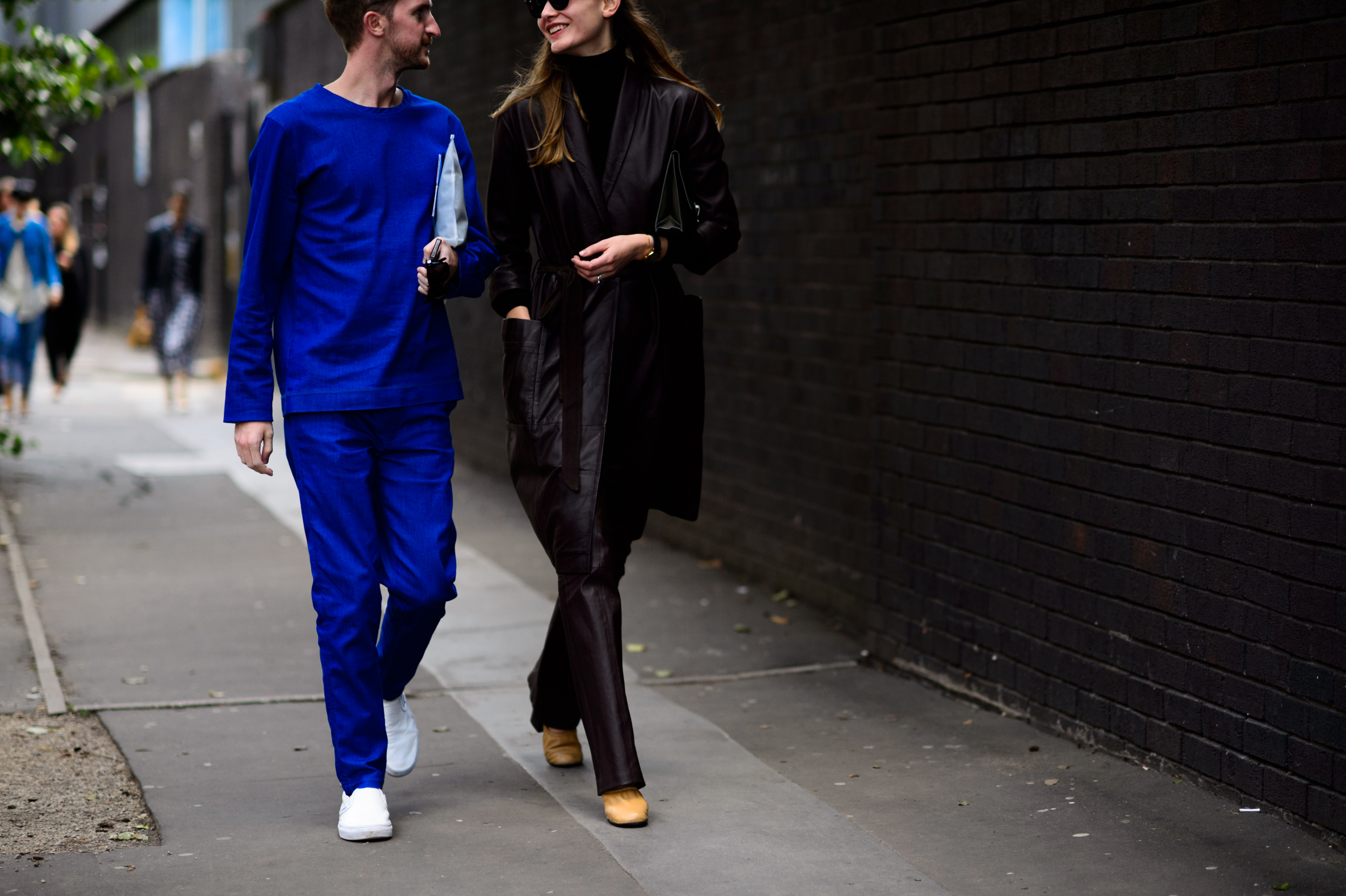 Man in red suit and woman in leather coat together