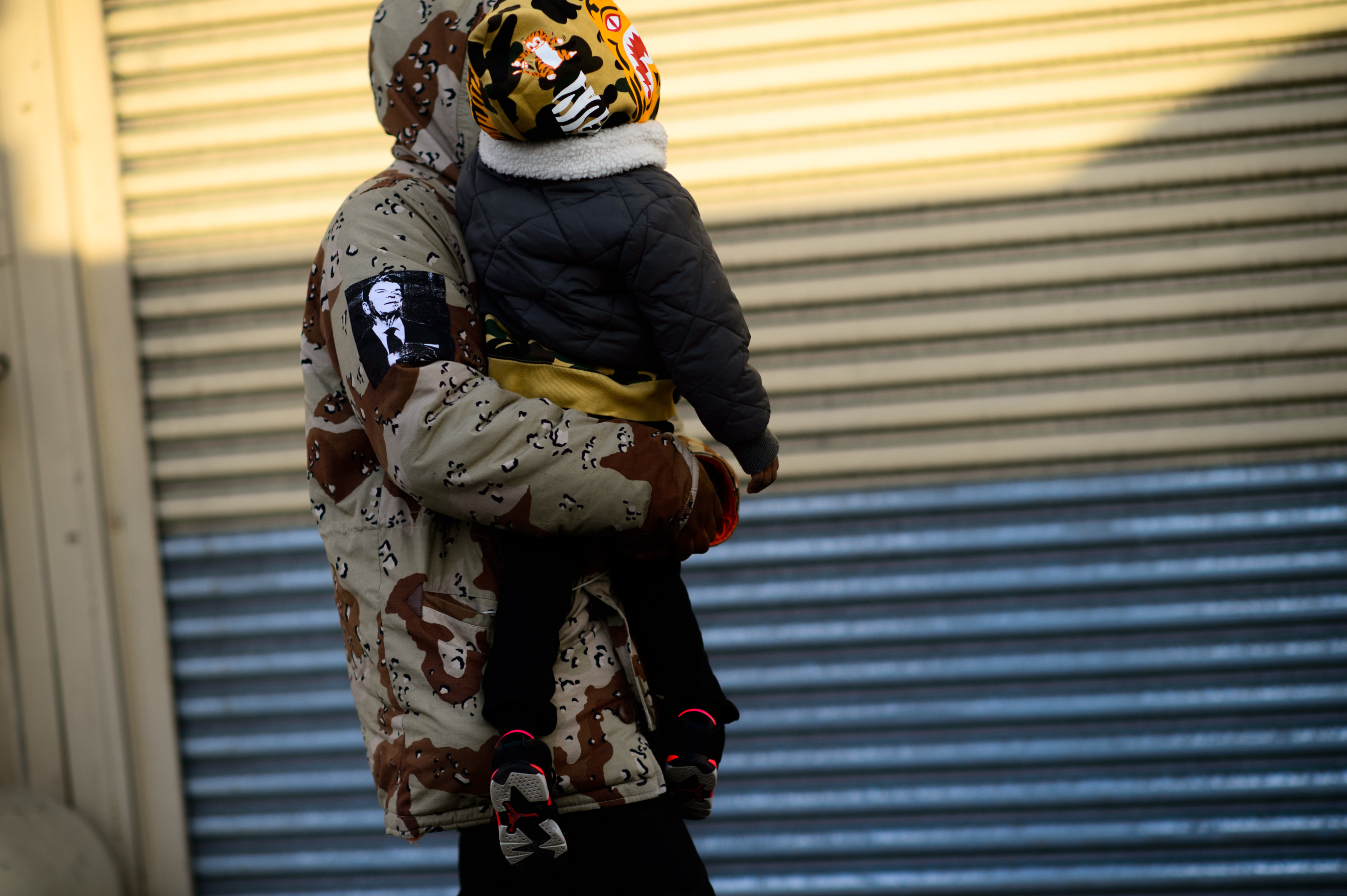 Man carrying his baby in camo outfit