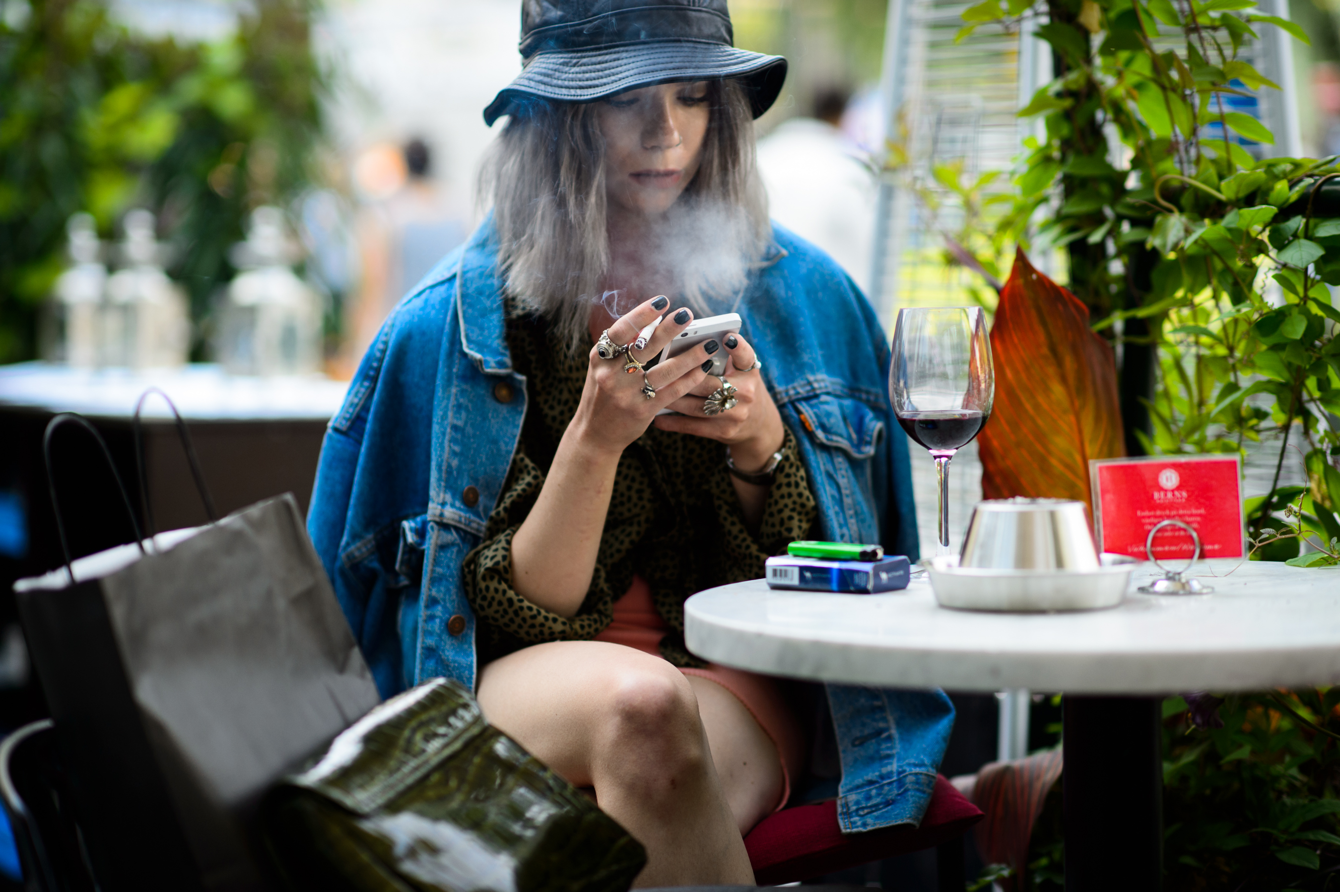 Woman wearing bucket hat and denim jacket at the cafe