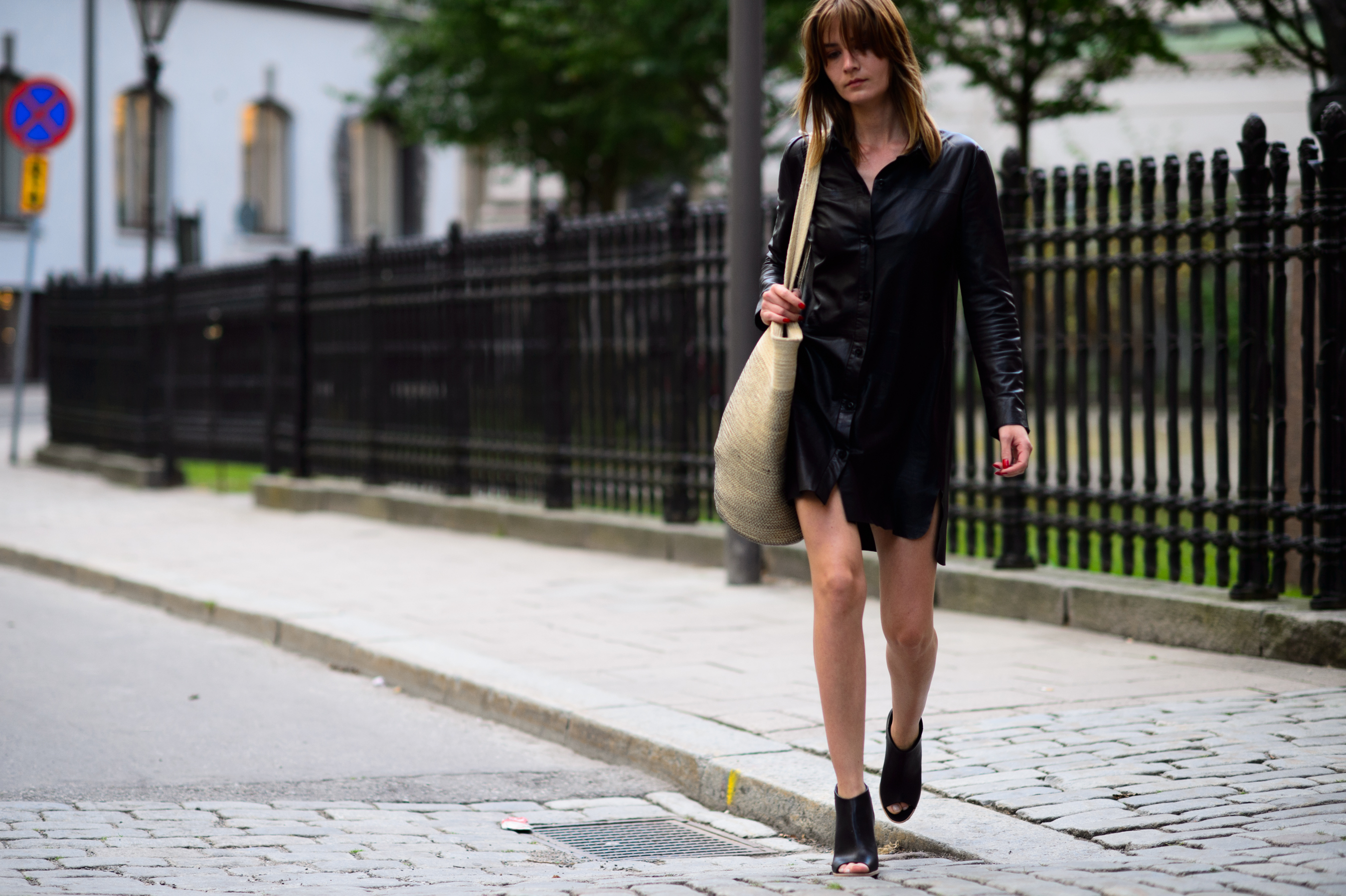 Woman wearing short leather dress and black shoes