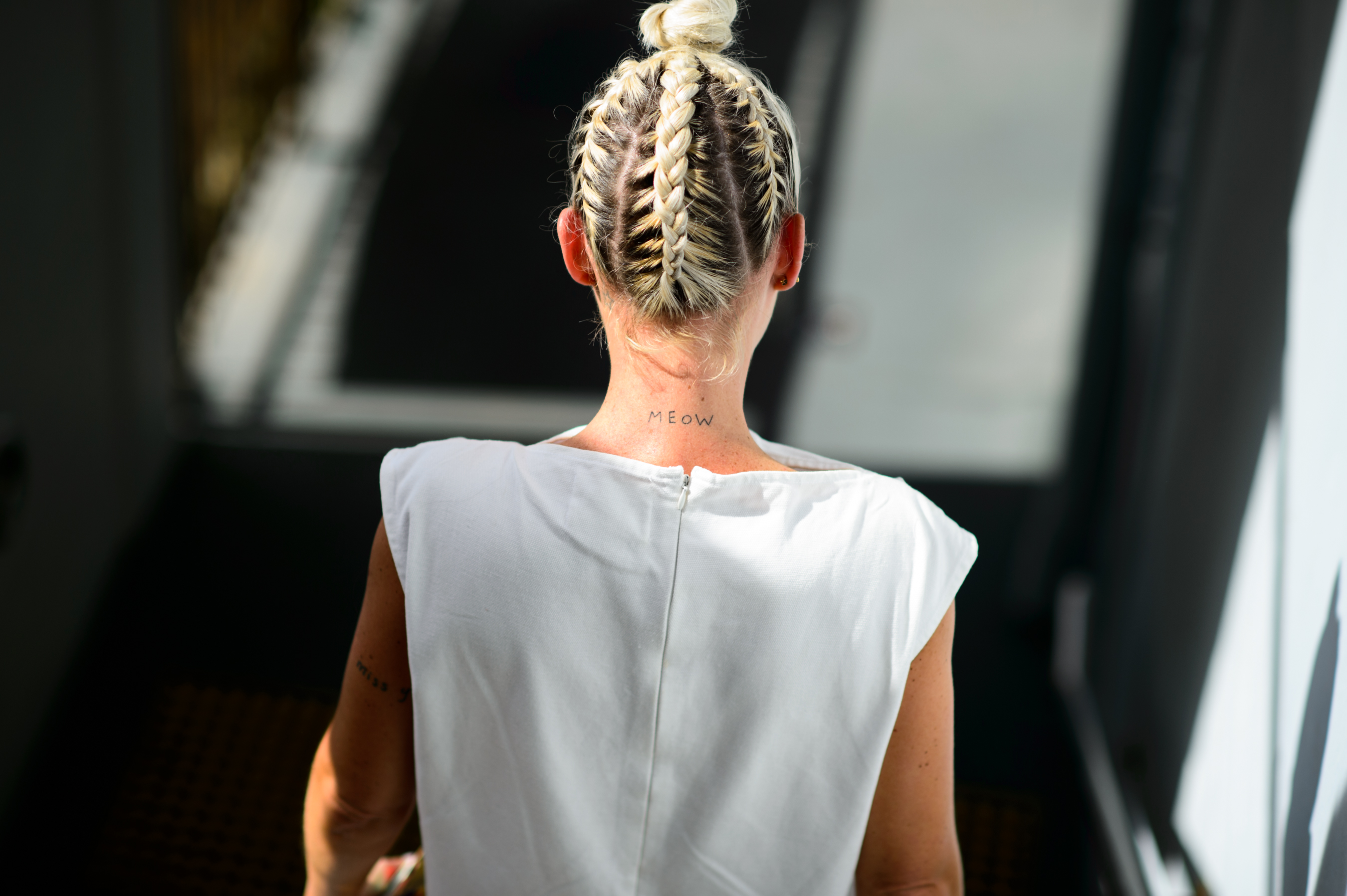 Model with "Meow" tattoo on her neck and braided hair