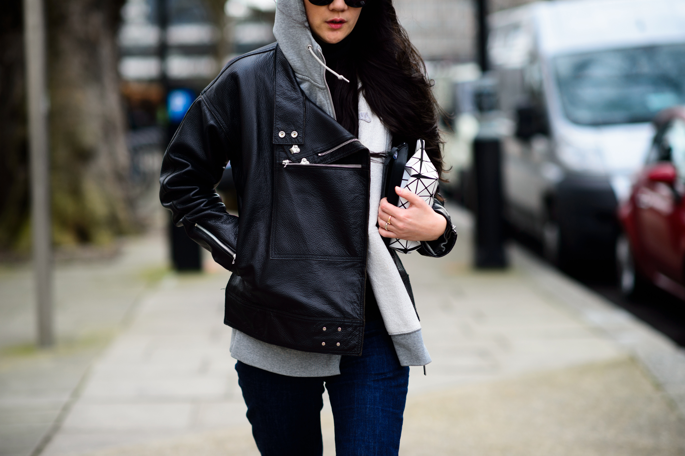 Woman wearing leather jacket and puzzle clutch