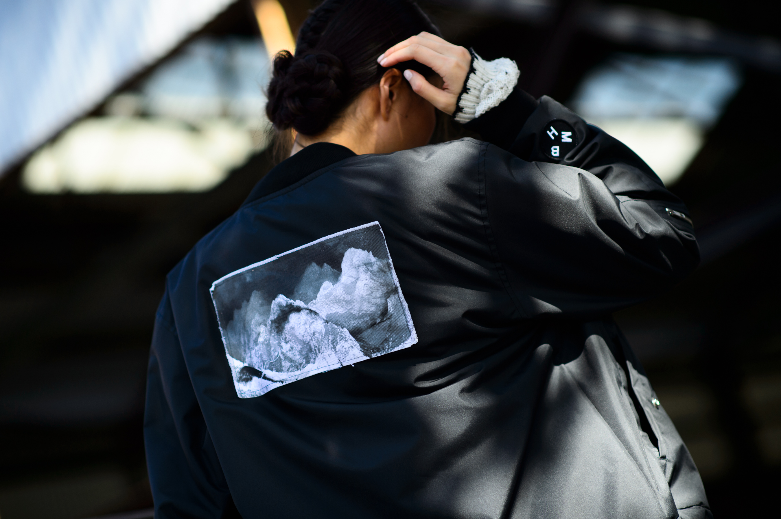 Woman in black jacket with mountains photo on the back
