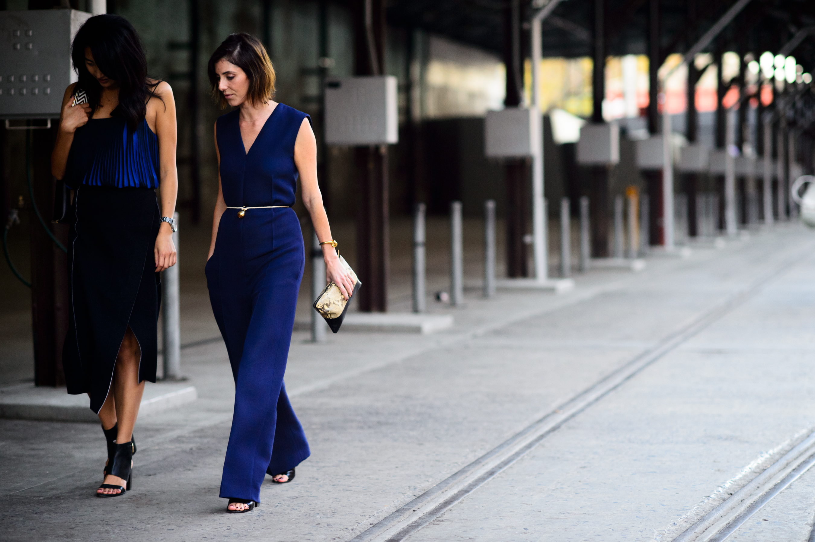 Two women wearing blue with gold accessories