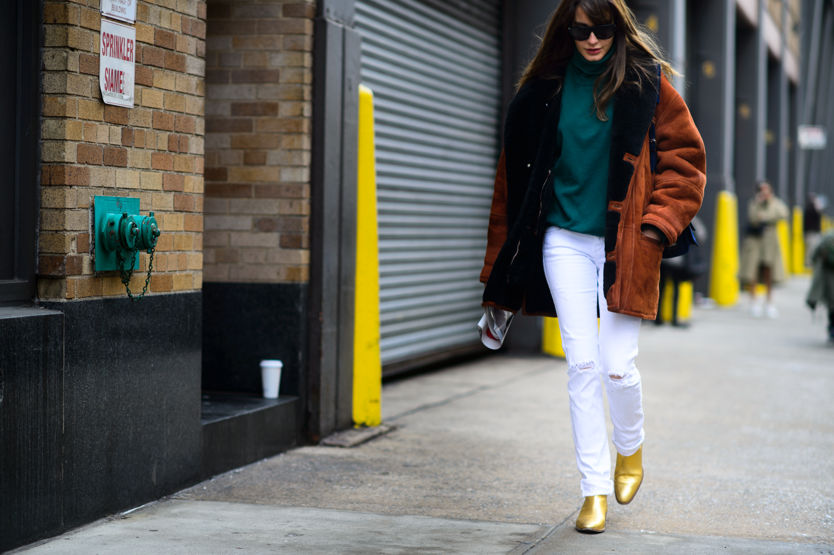 Turkish stylist wearing golden boots and sheepskin coat