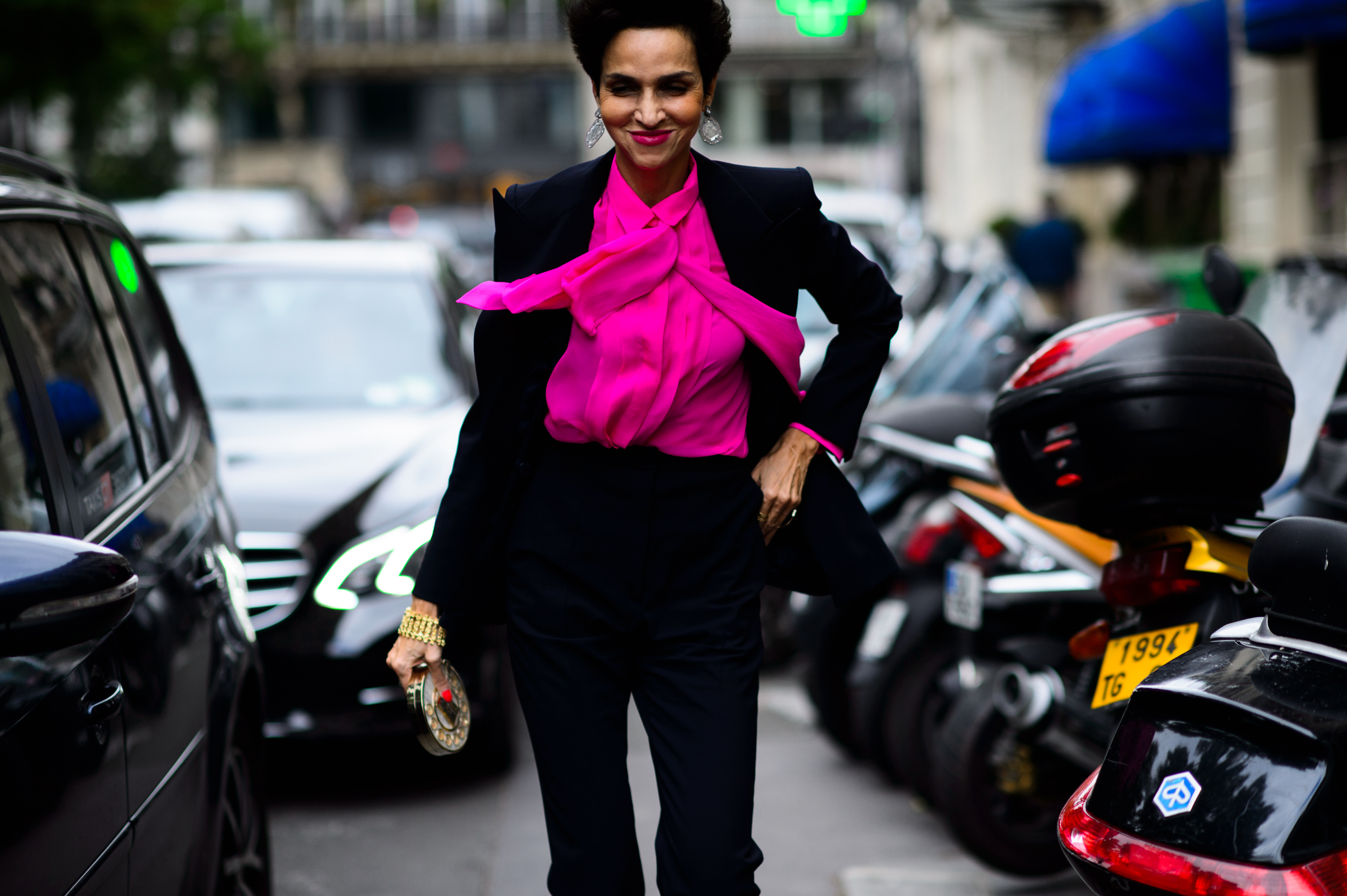 Woman with short hair wearing pink top with bow tie