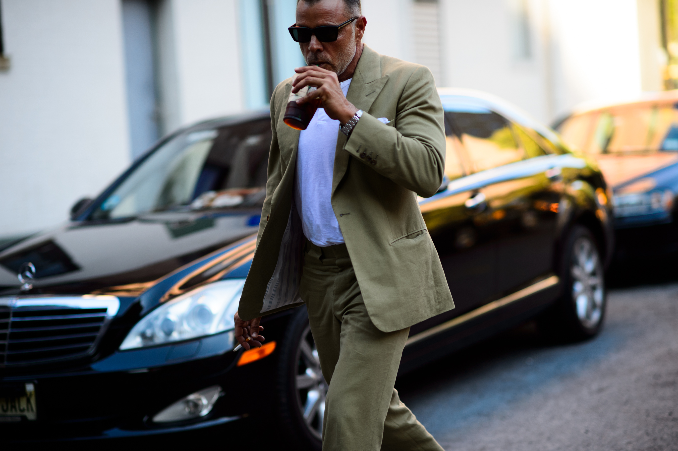 Man wearing sand suit and drinking coffee