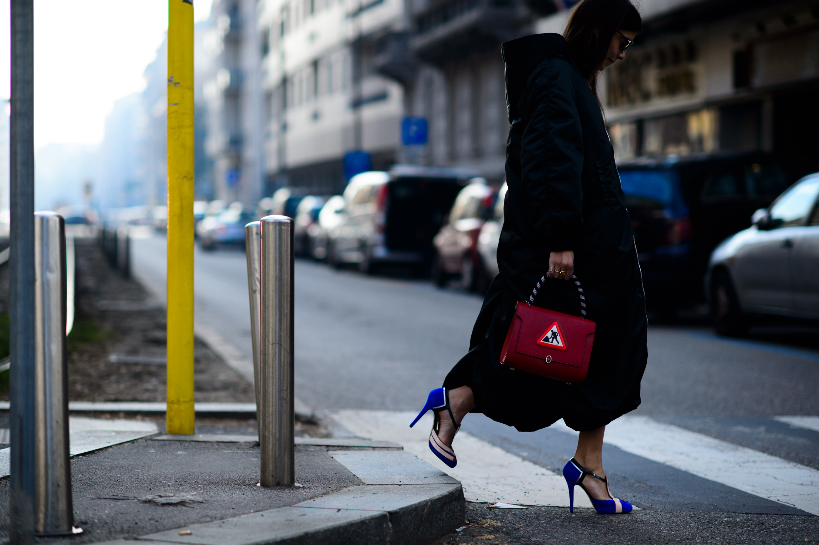 Woman wearing black coat and red bag