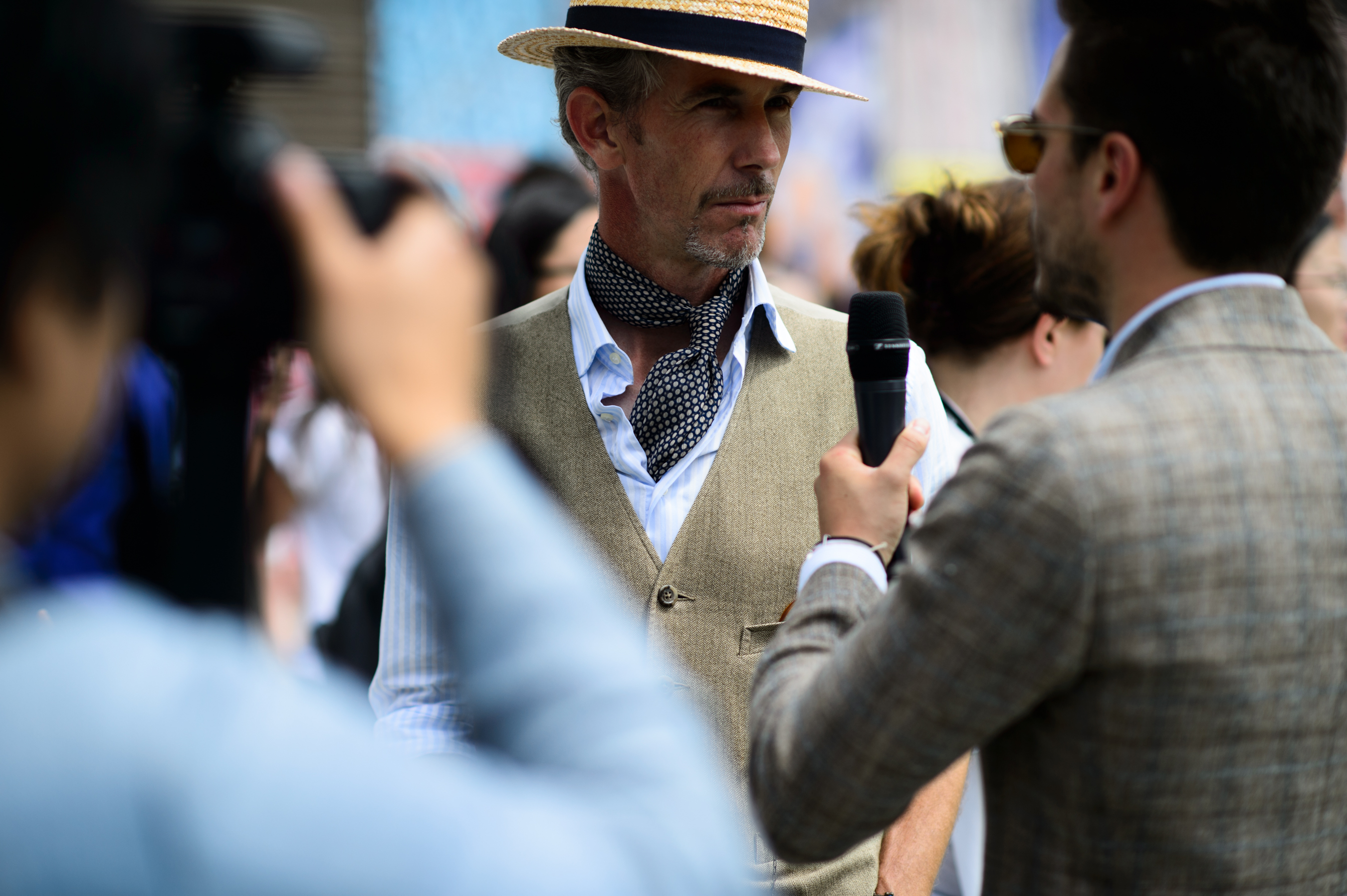 Man giving an interview wearing hat and vest
