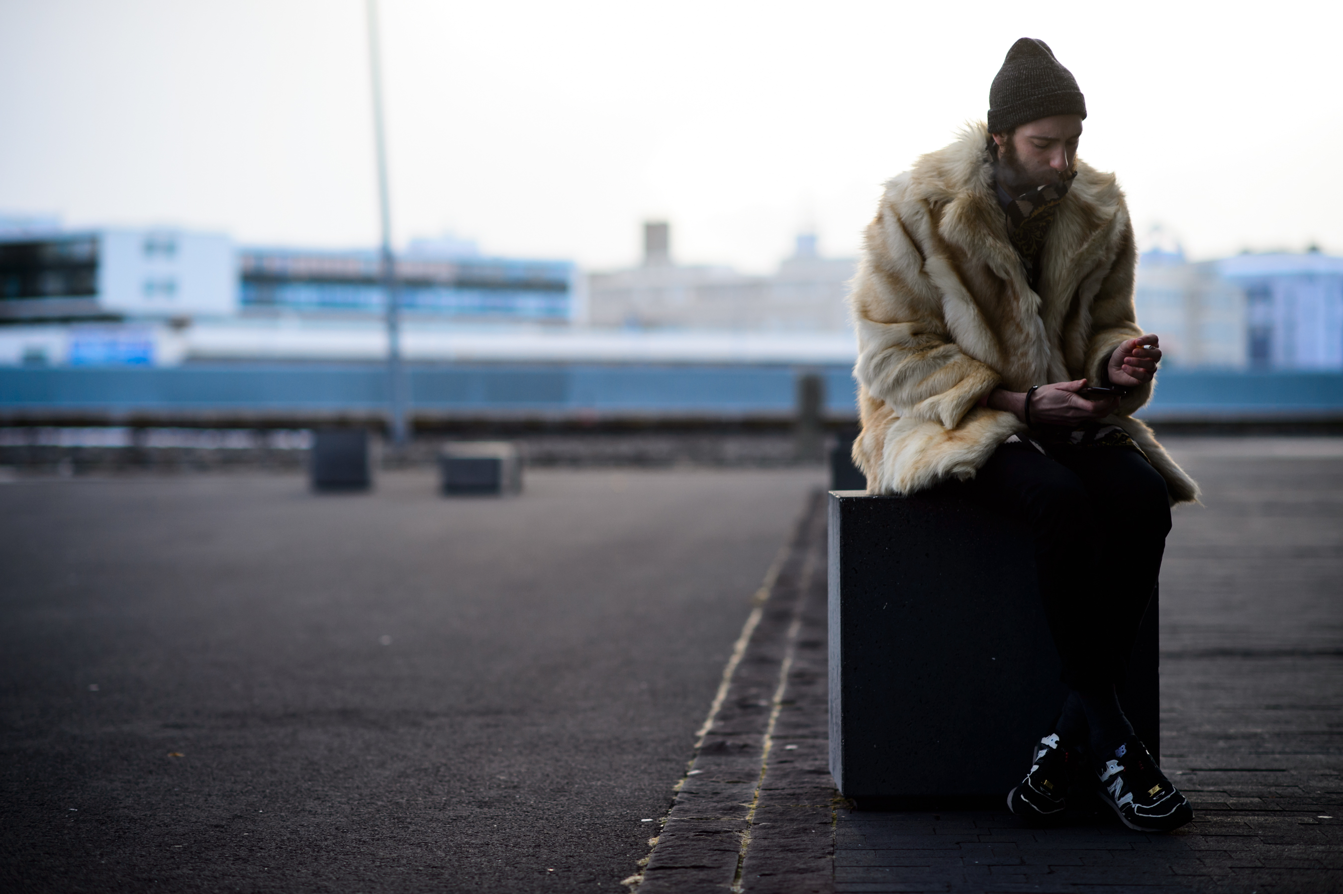 Man in a fur coat sitting outside of the venue