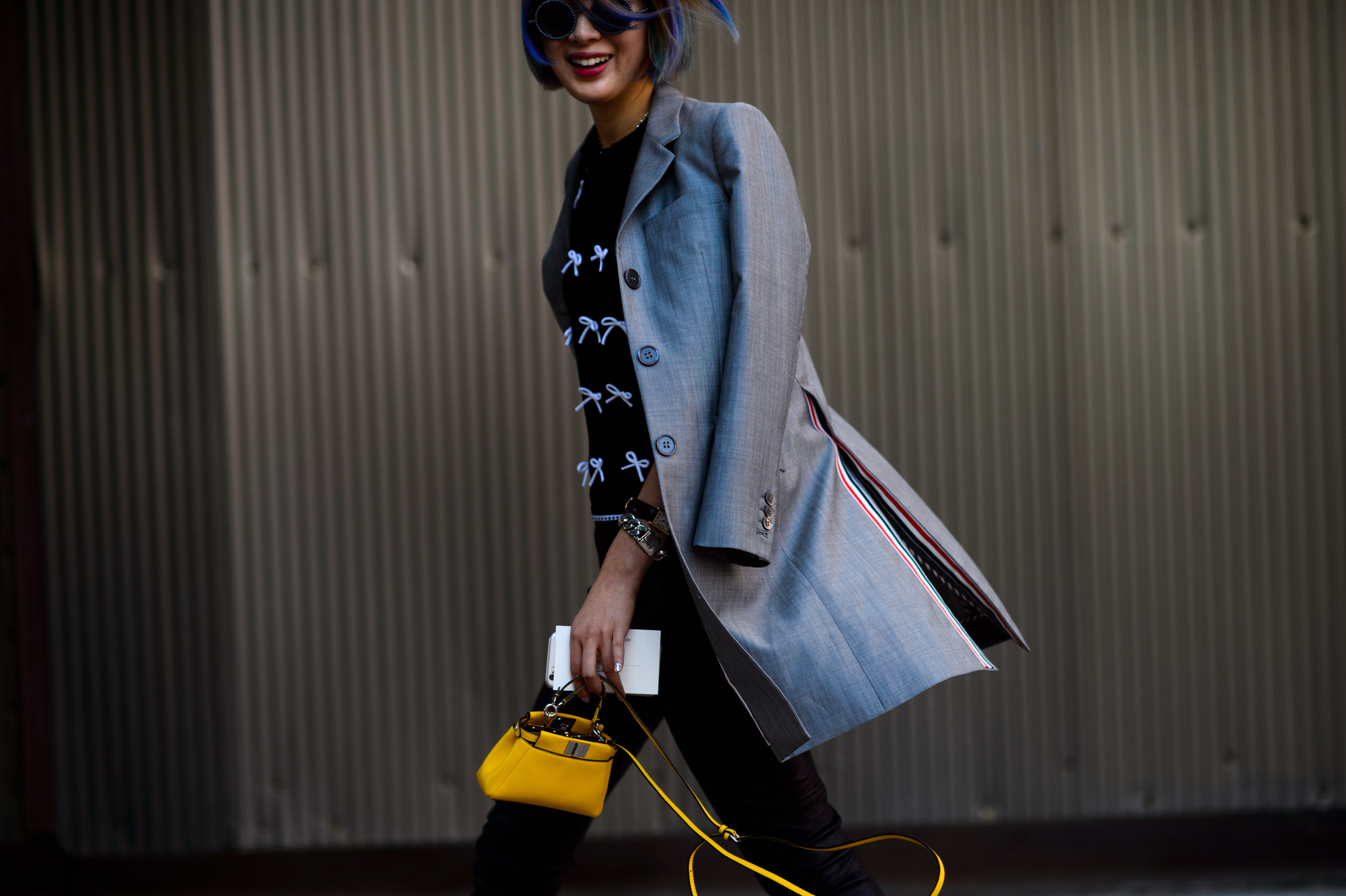 Korean journalist wearing grey coat and yellow bag