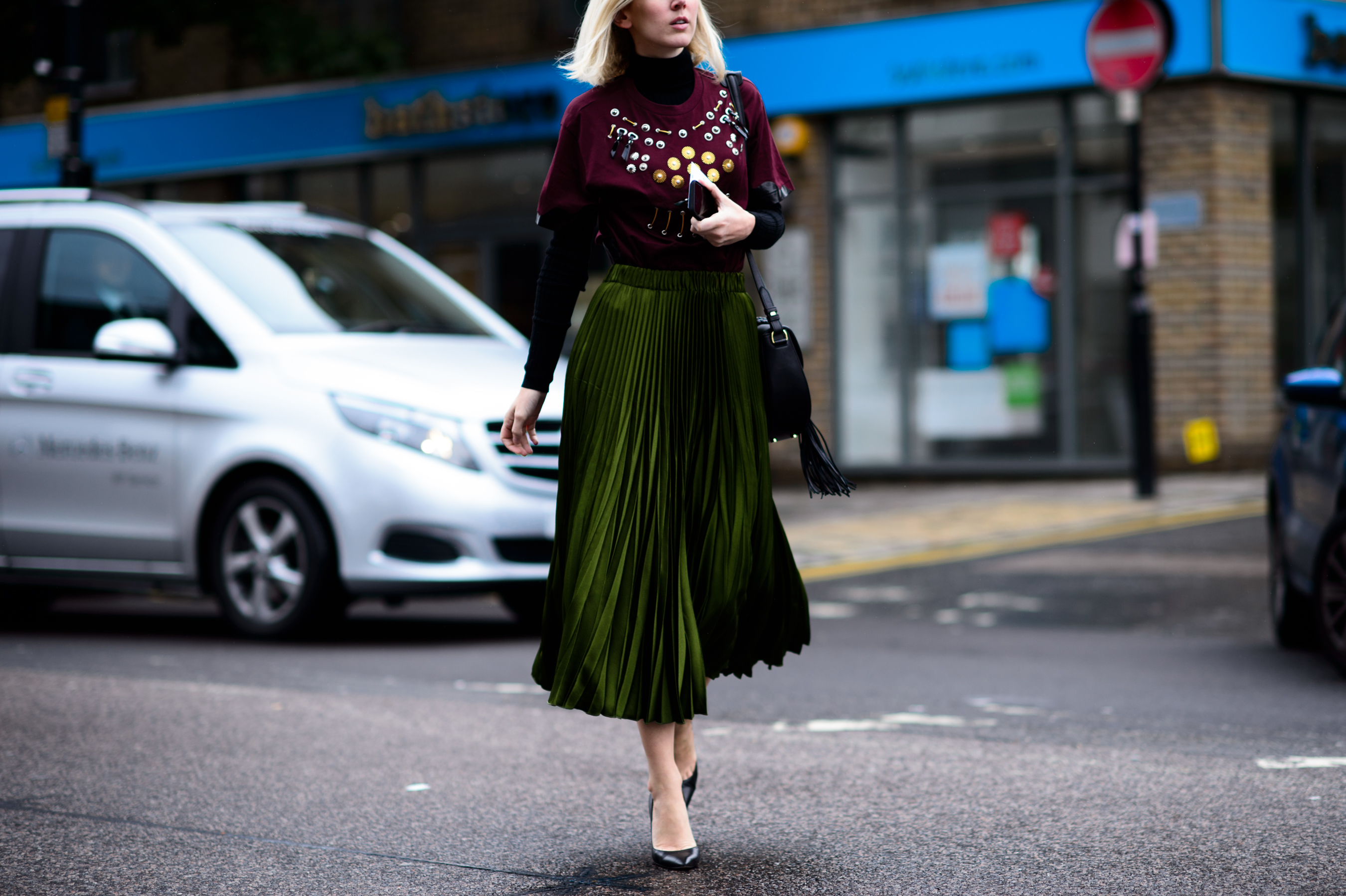 Fashion news director wearing green skirt and burgundy top