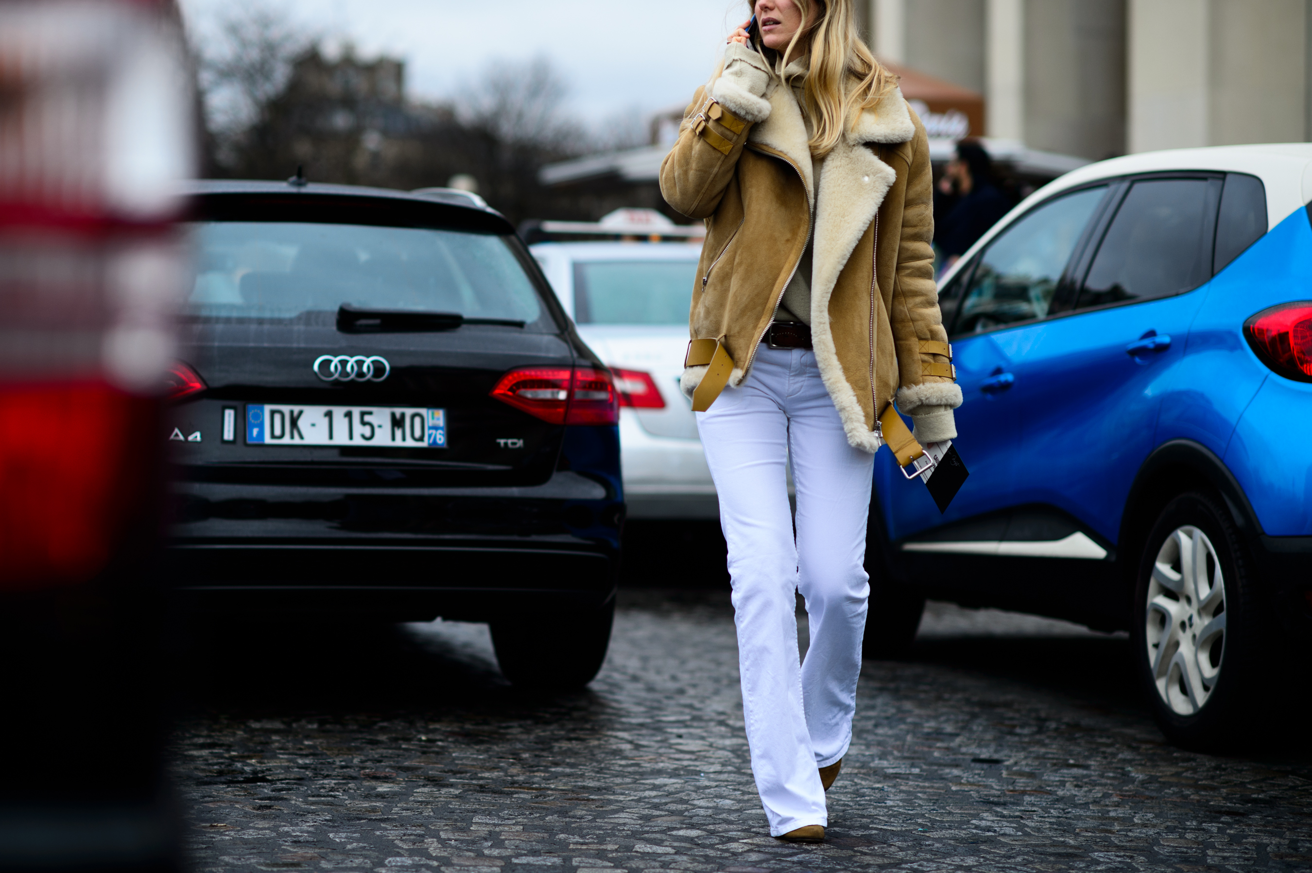 Woman wearing shearling coat and white pants