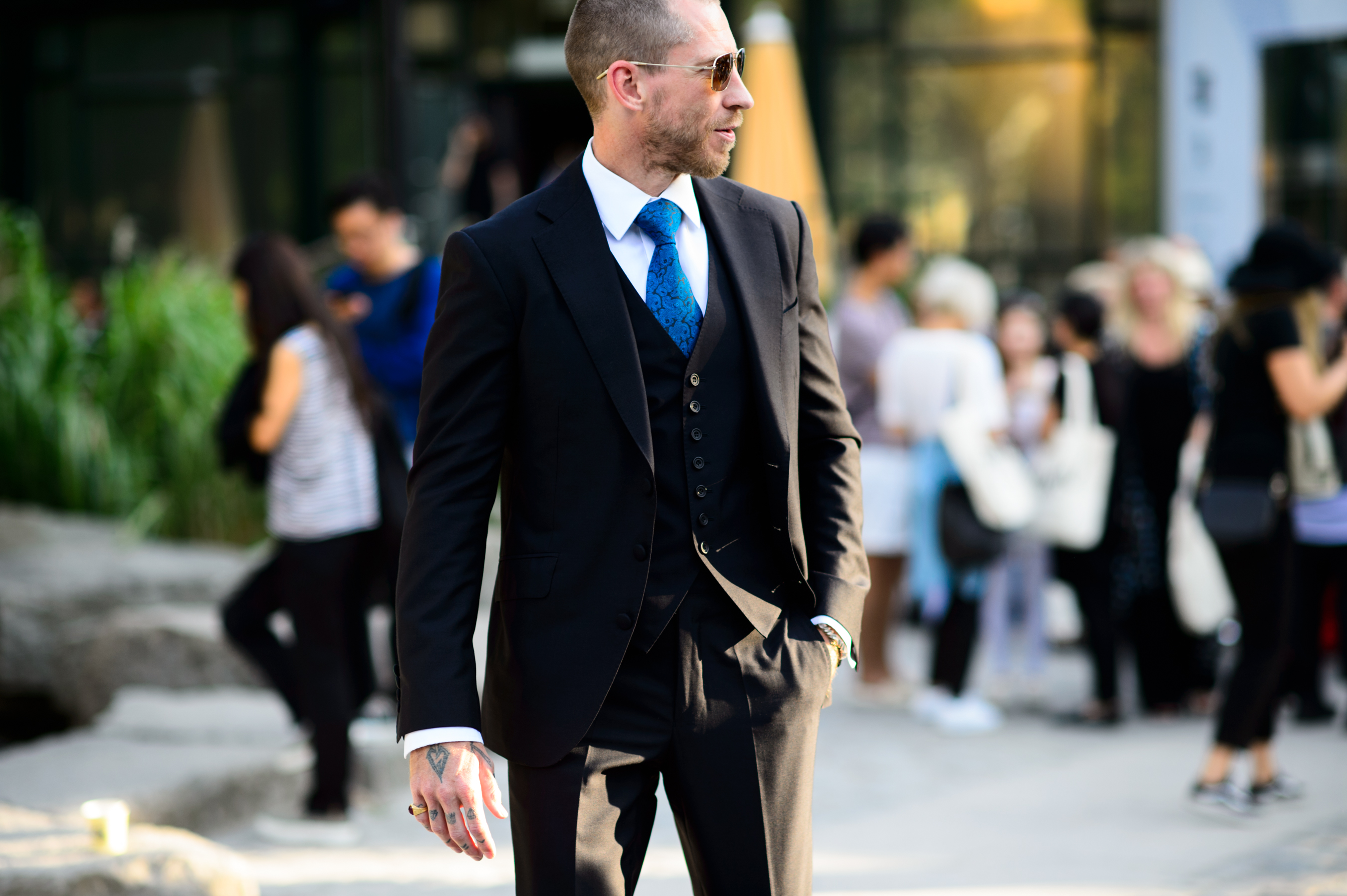 Man wearing black suit with blue tie