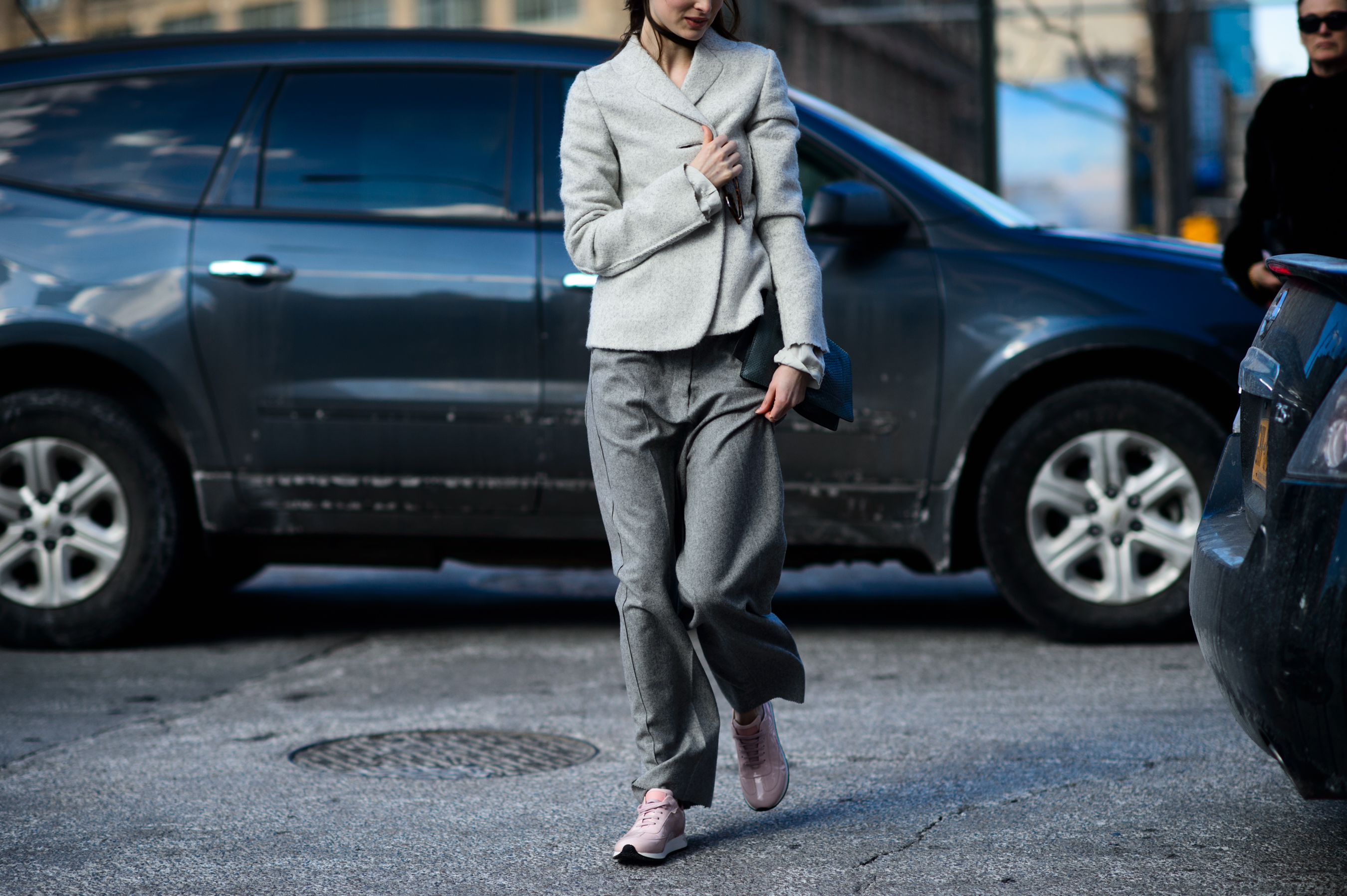 Woman wearing gray suit and pink sneakers