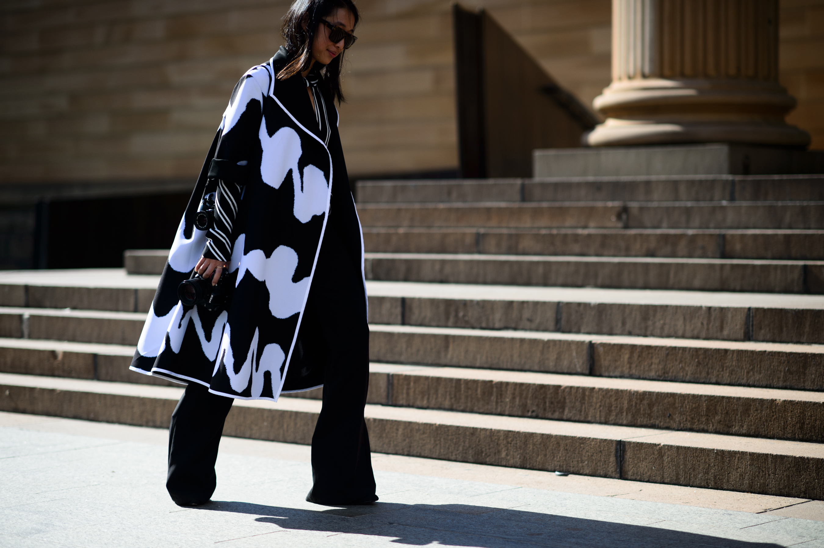 Australian photographer wearing oversized coat and wide pants