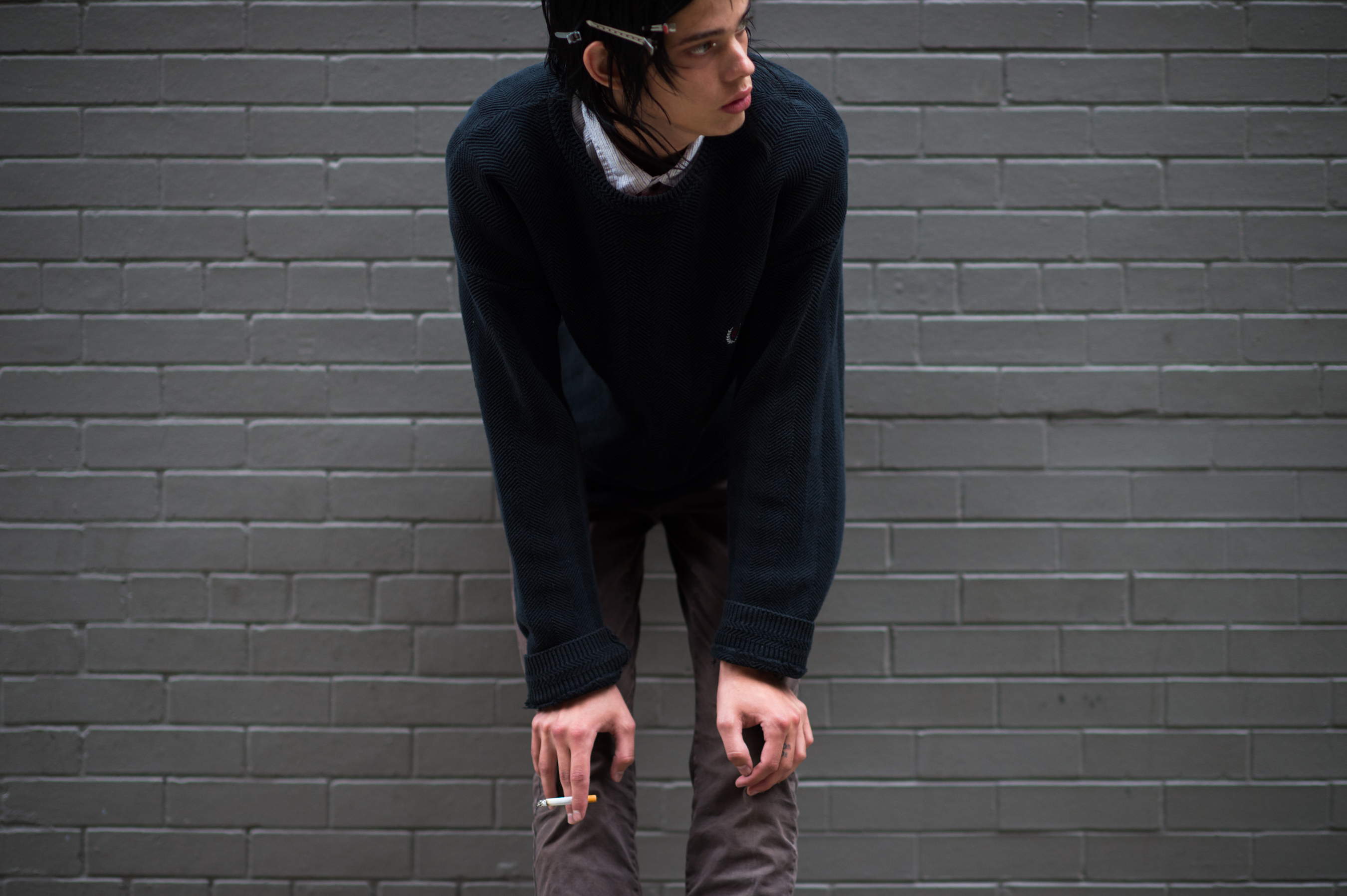 Male model with clipped hair smoking