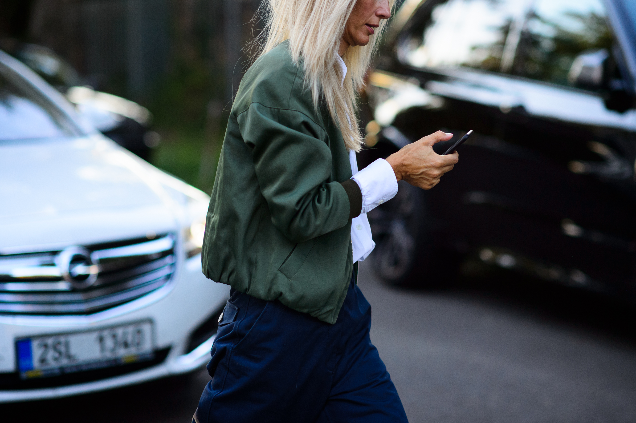 Woman with white hair wearing green bomber jacket