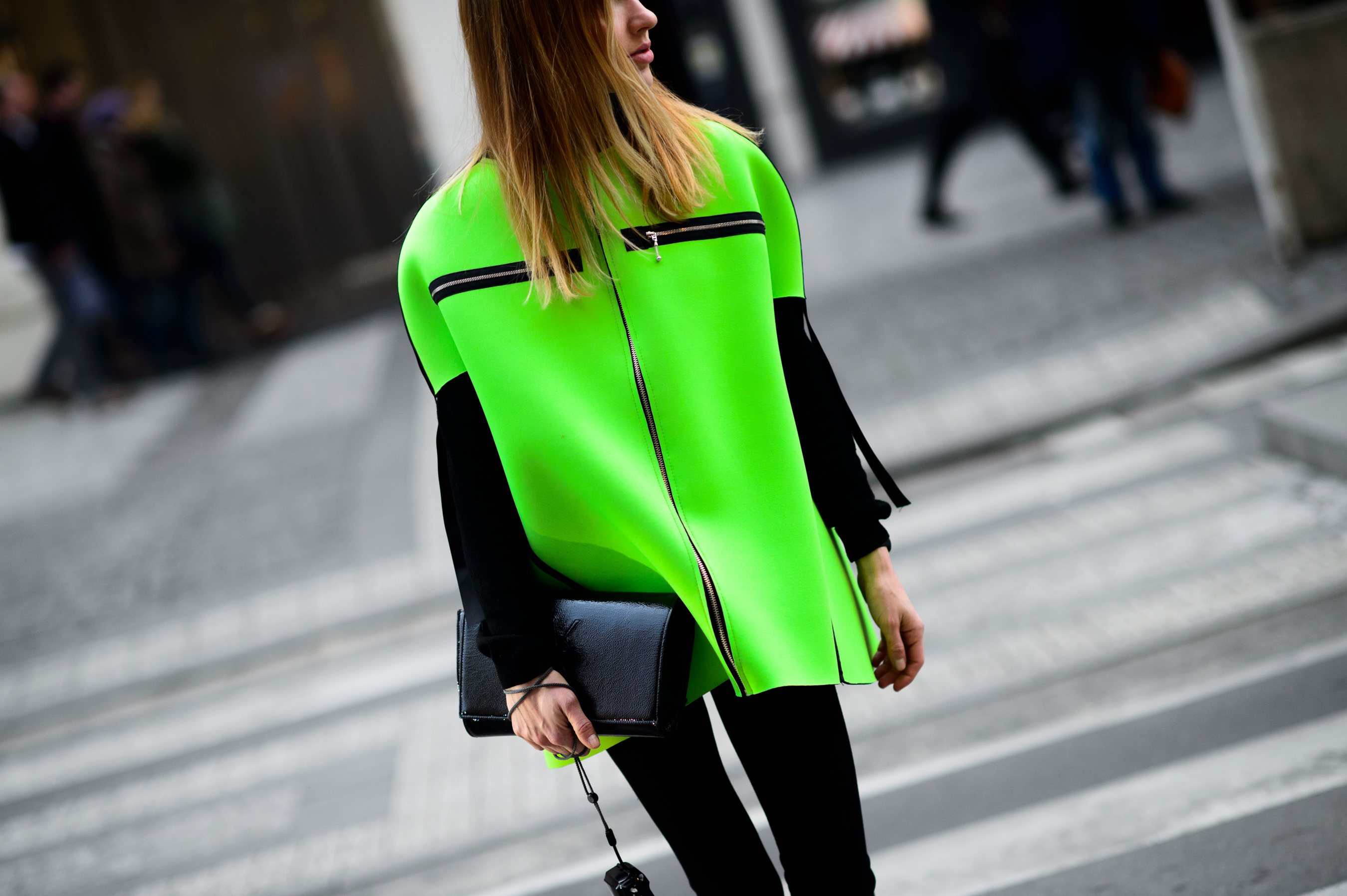 Woman in neon green cape crossing the road