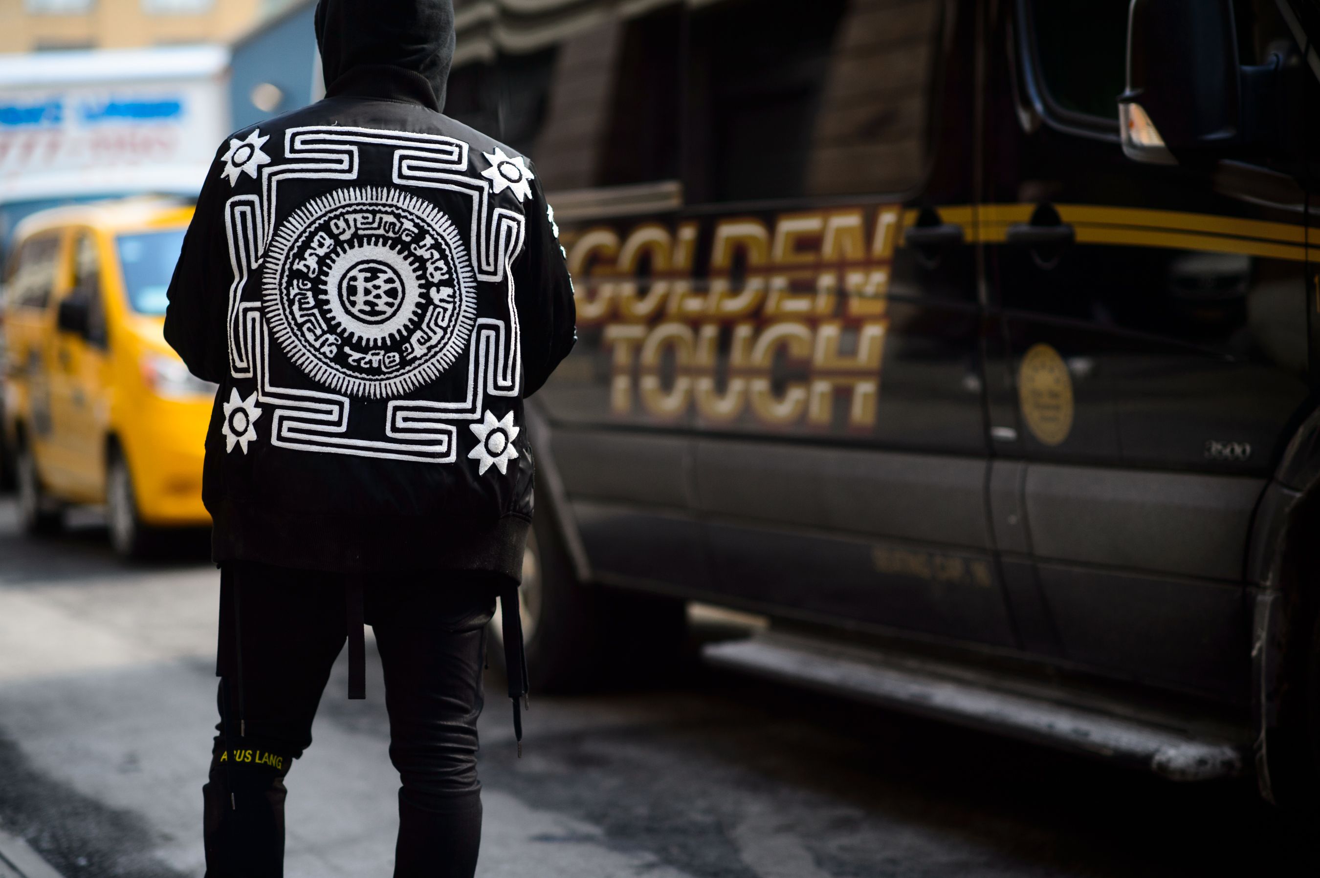 French street style photographer wearing jacket with graphics