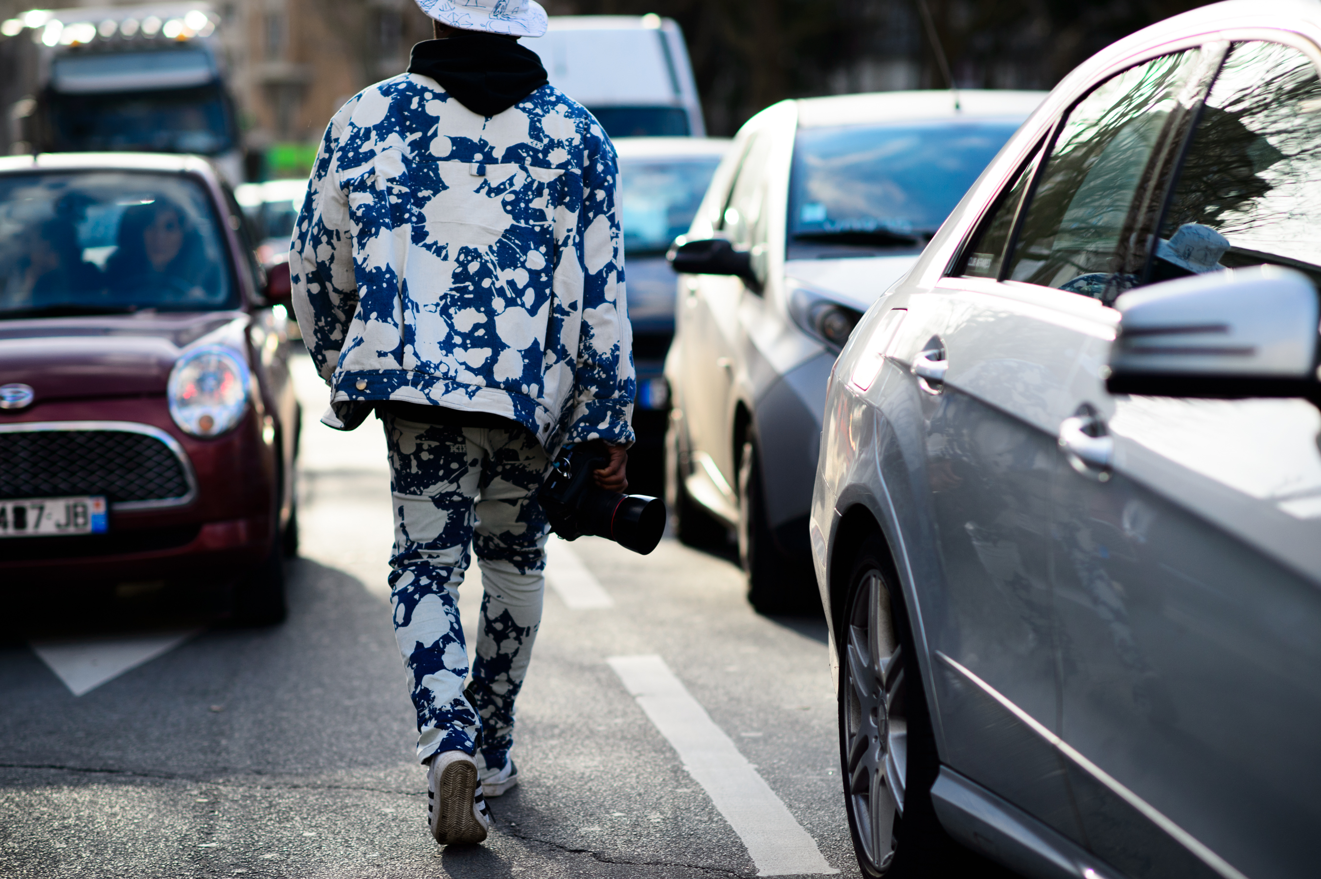 French street style photographer wearing paint splashed suit