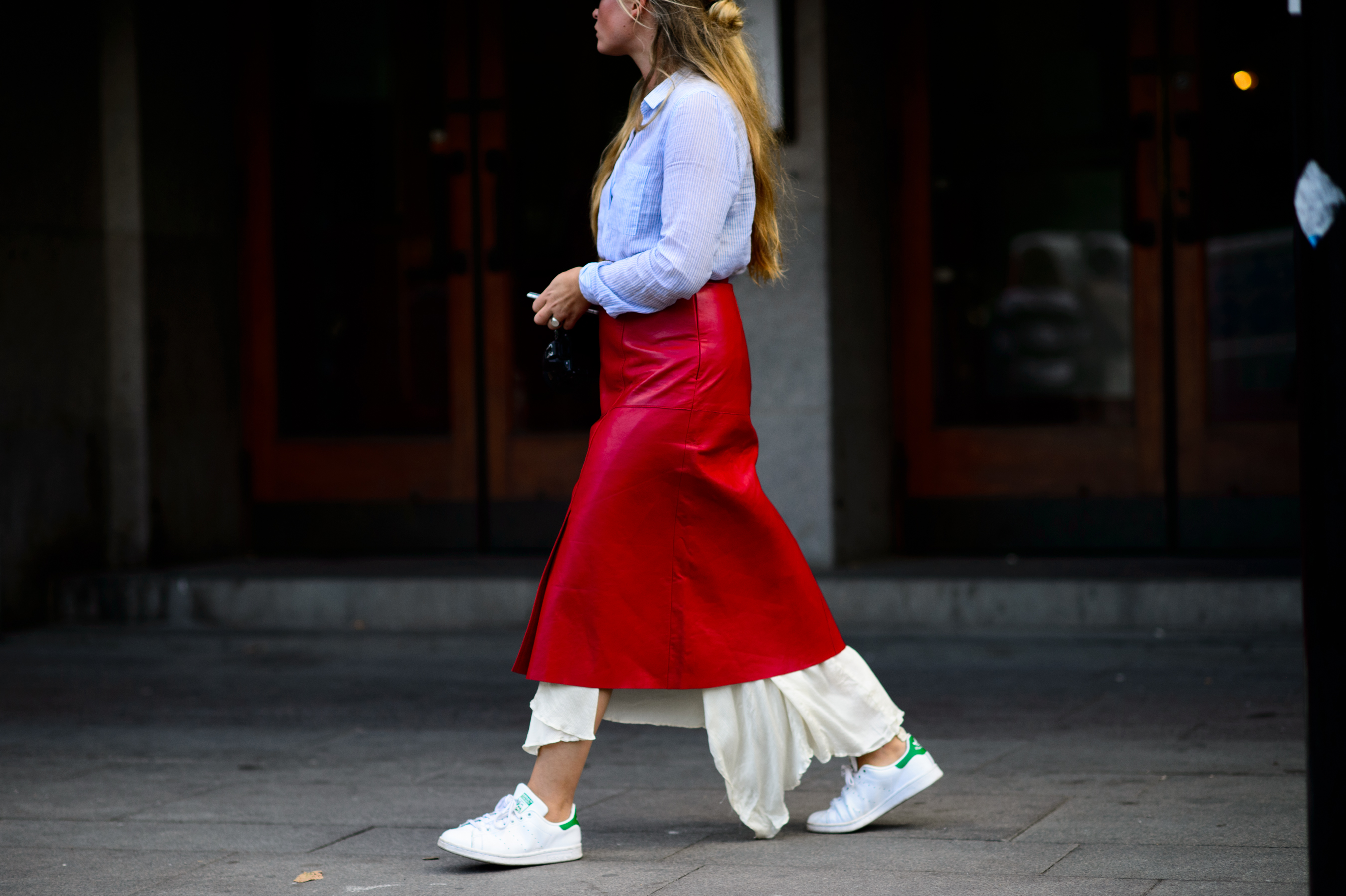 Woman wearing red leather skirt and sneakers