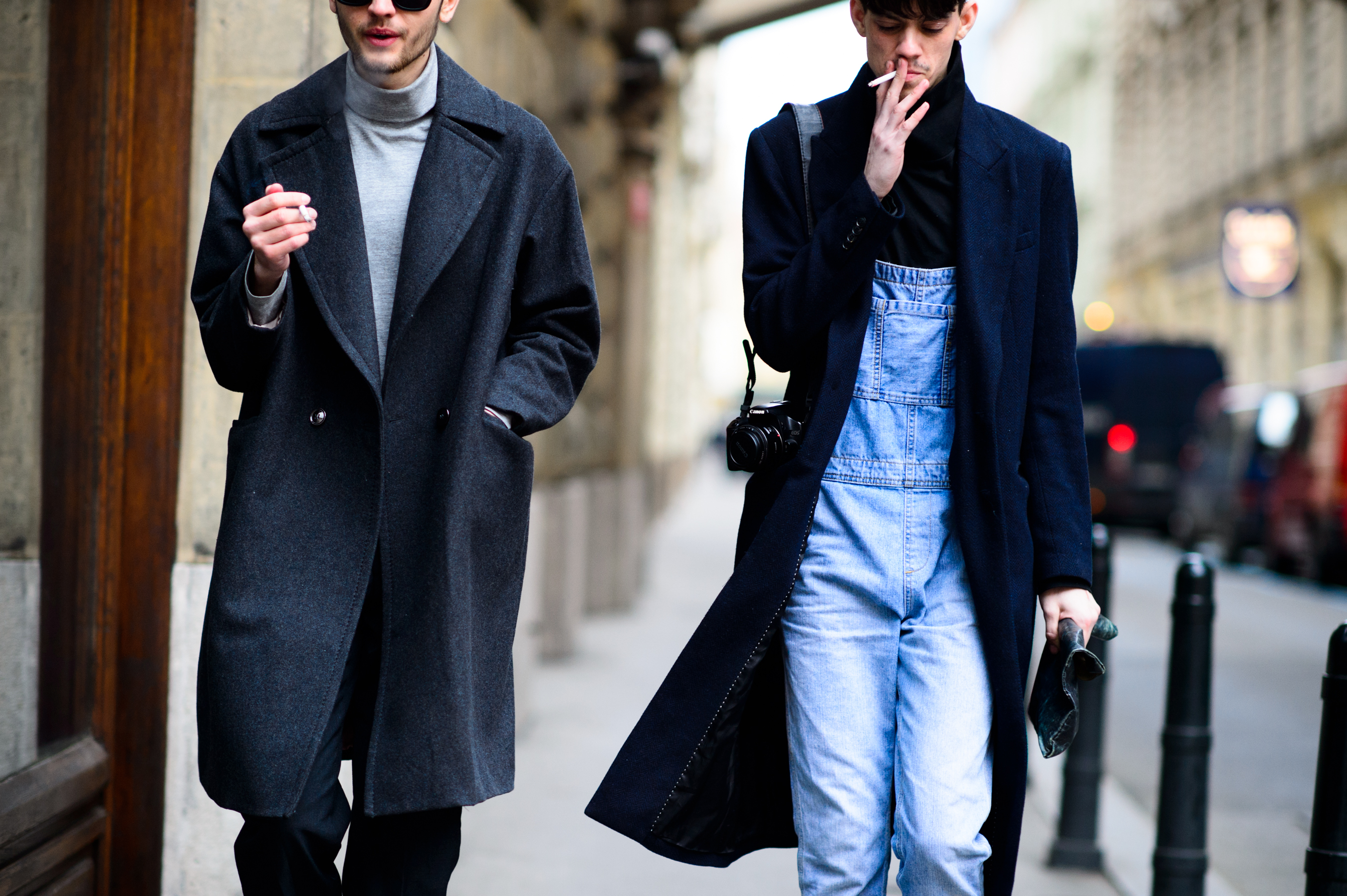 Two men wearing coats and smoking