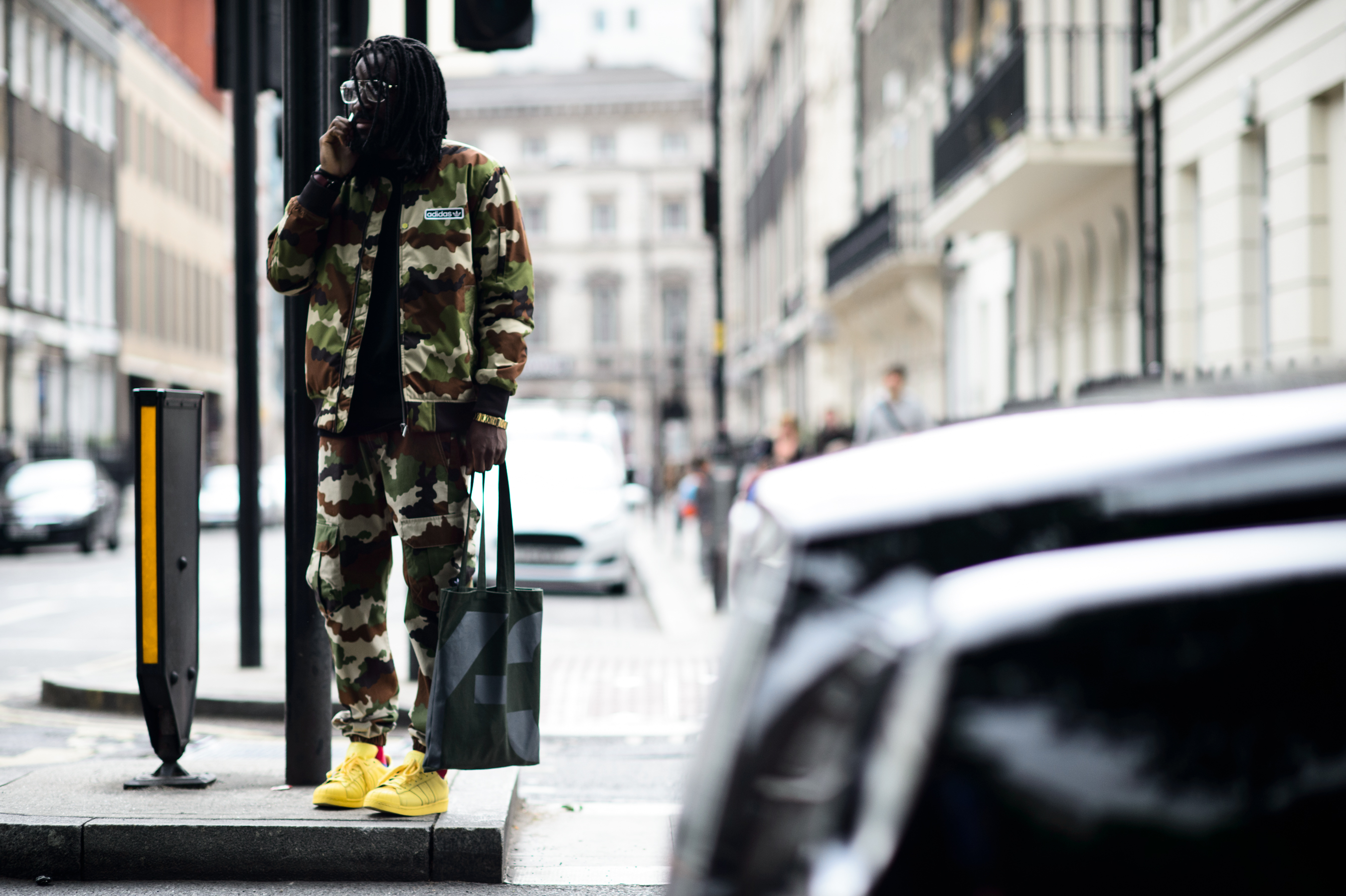 Man wearing camouflage costume with yellow sneakers