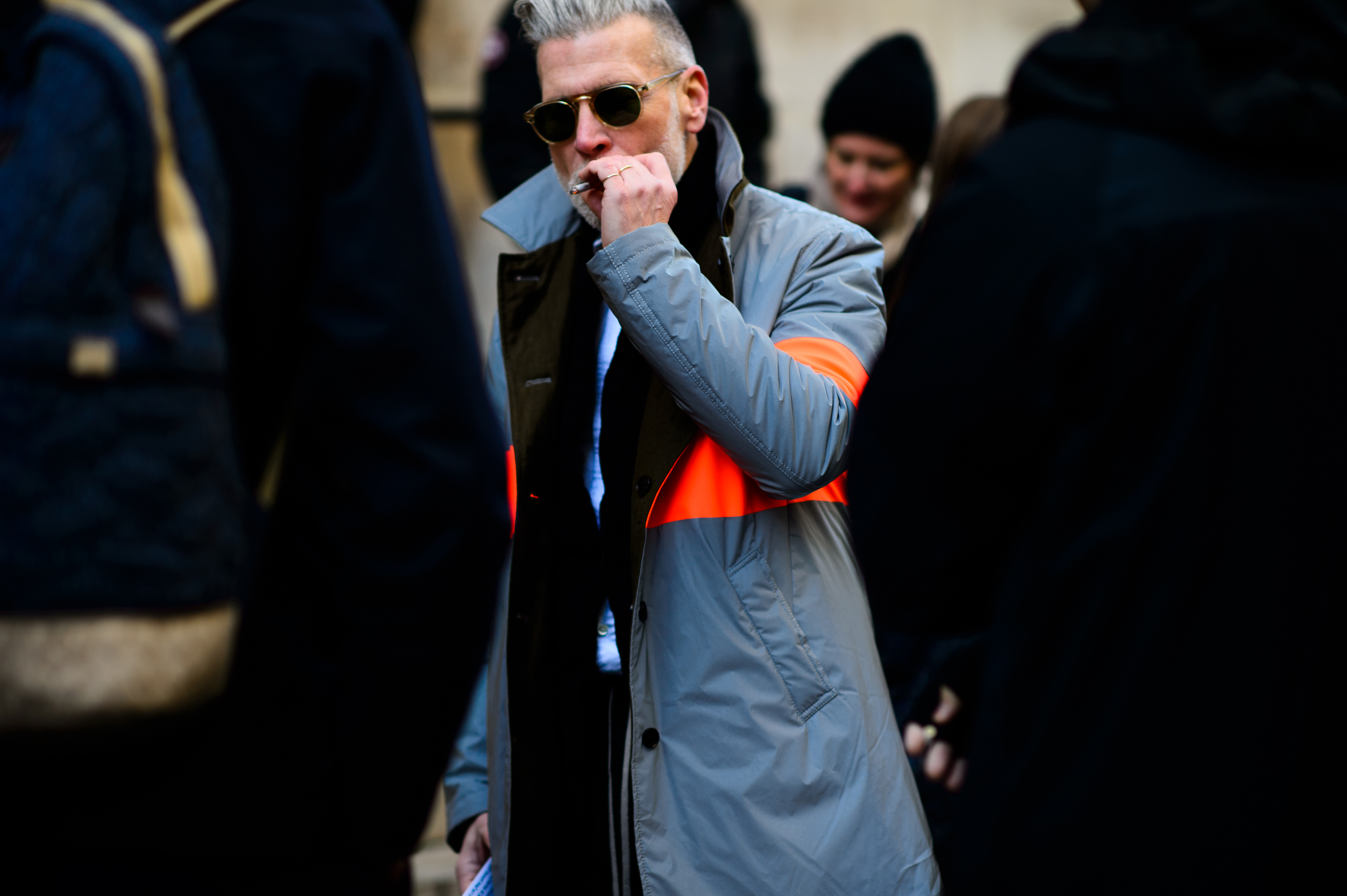 American man wearing grey coat with orange stripe